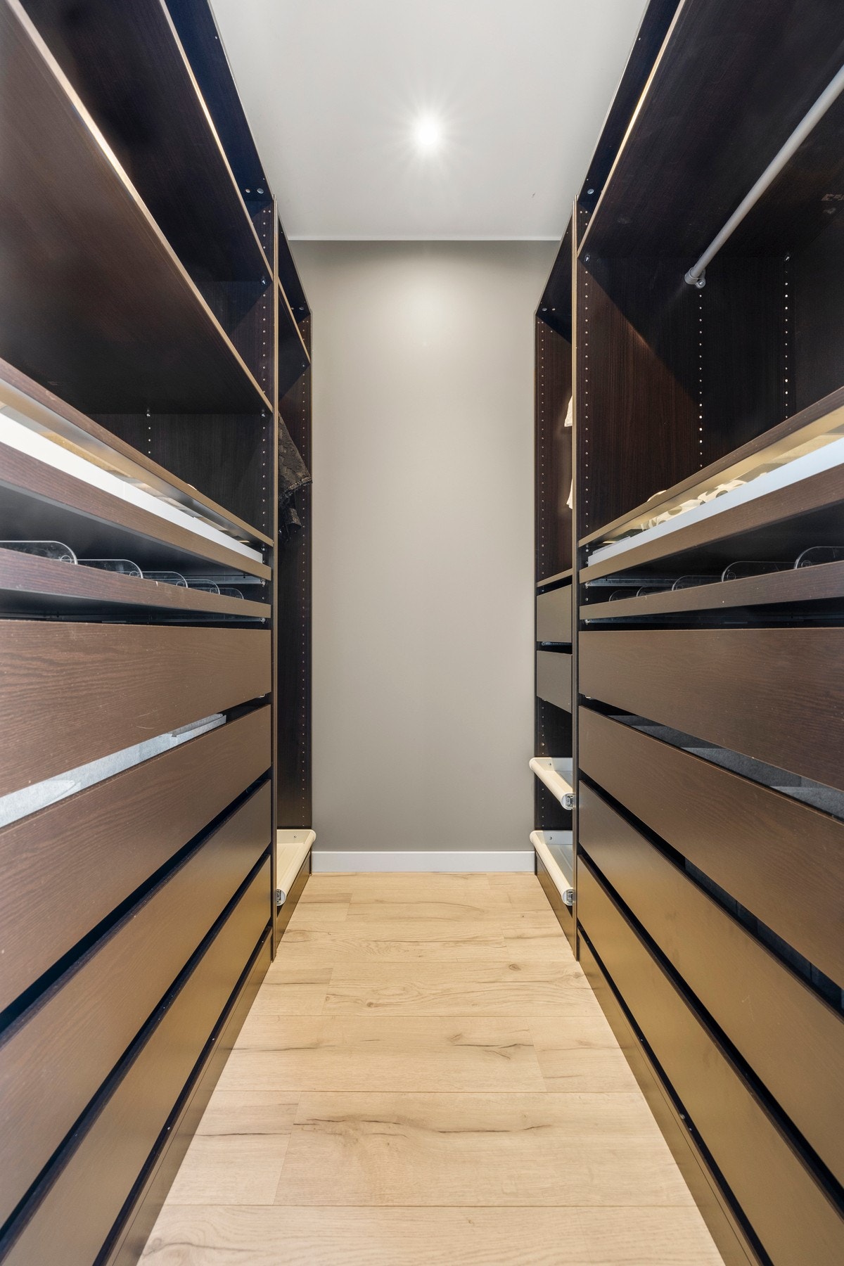 Et moderne walk-in closet med skreddersydde løsninger og innebygd belysning. Galleribilde