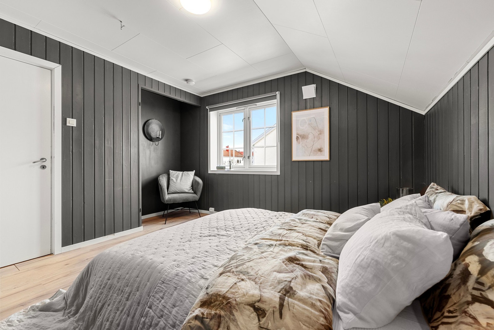 Skråtaket gir rommet en koselig atmosfære, mens store vinduer sørger for rikelig med naturlig lys. Galleribilde