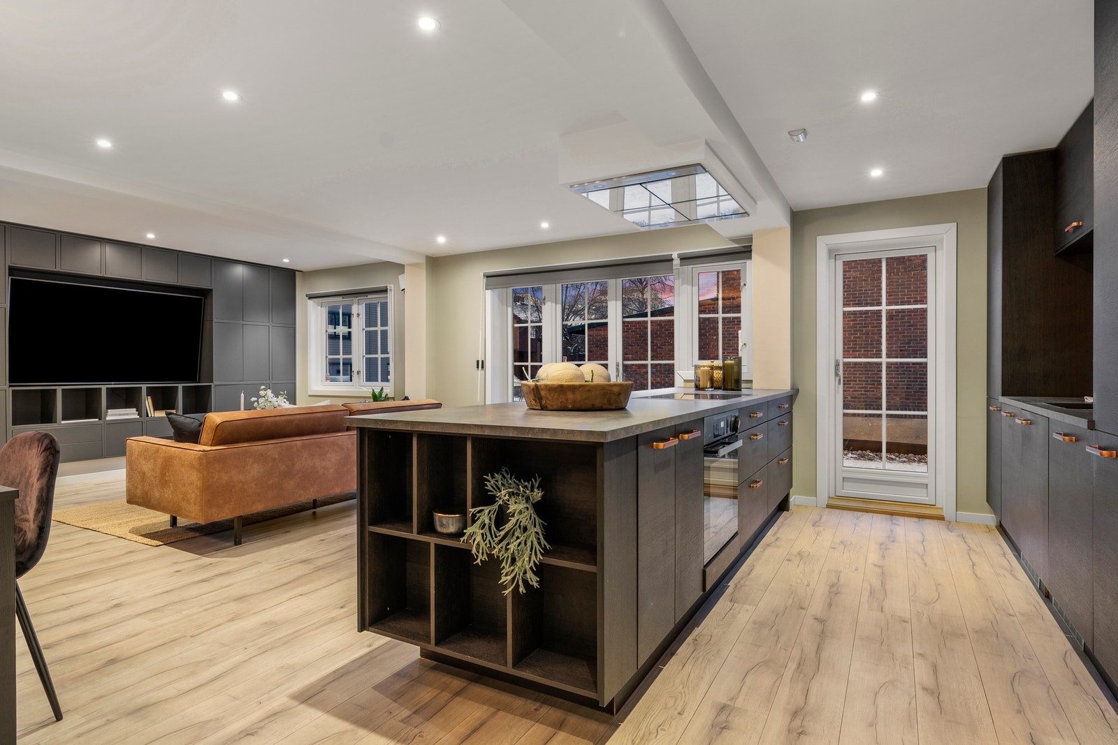 Det åpne kjøkkenet er designet med mørke fronter og innbyr til både matlaging og sosialt samvær. Galleribilde