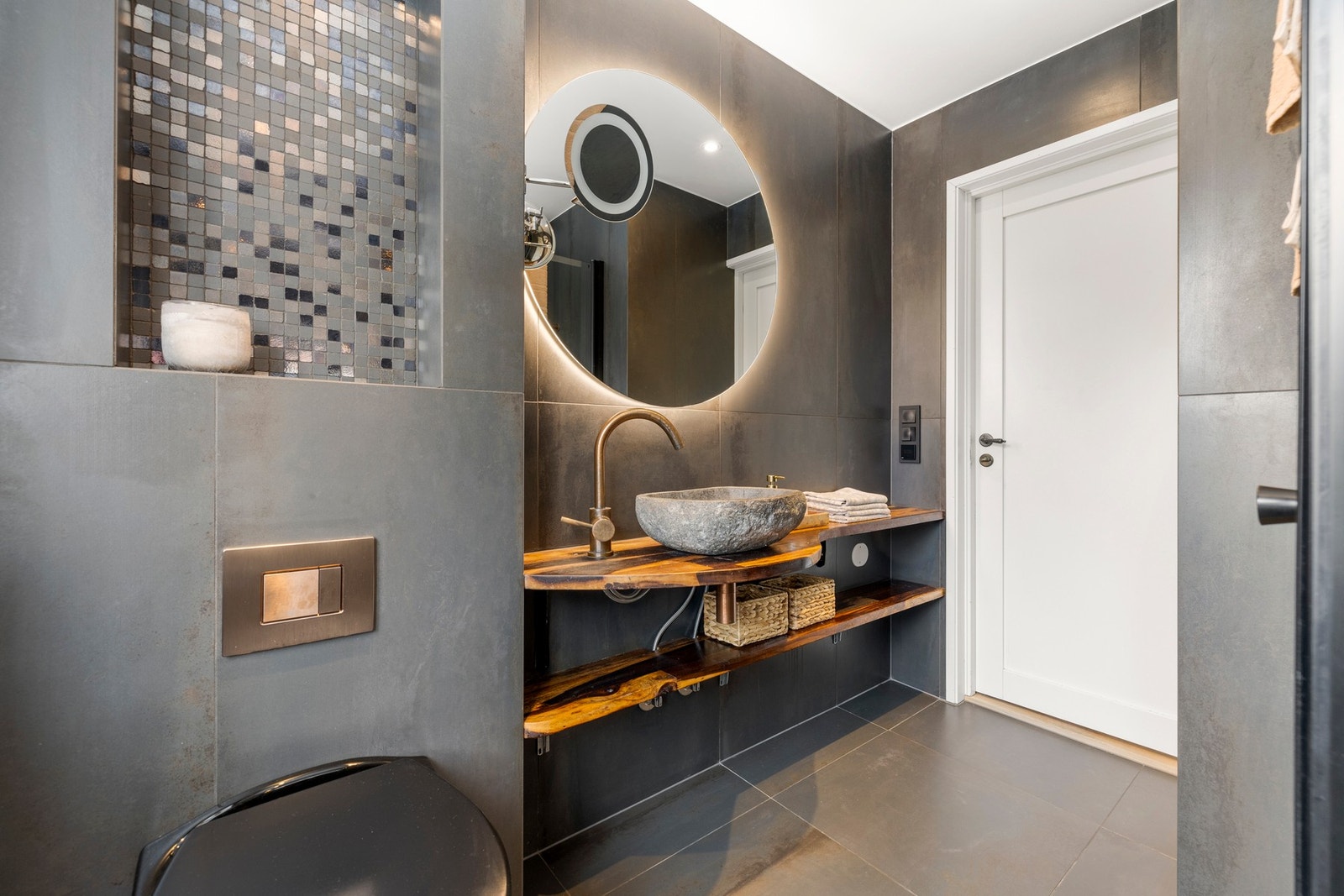 Den vakre servantløsningen i stein kombineres med en benkeplate i tre for en naturlig og luksuriøs kontrast. Galleribilde