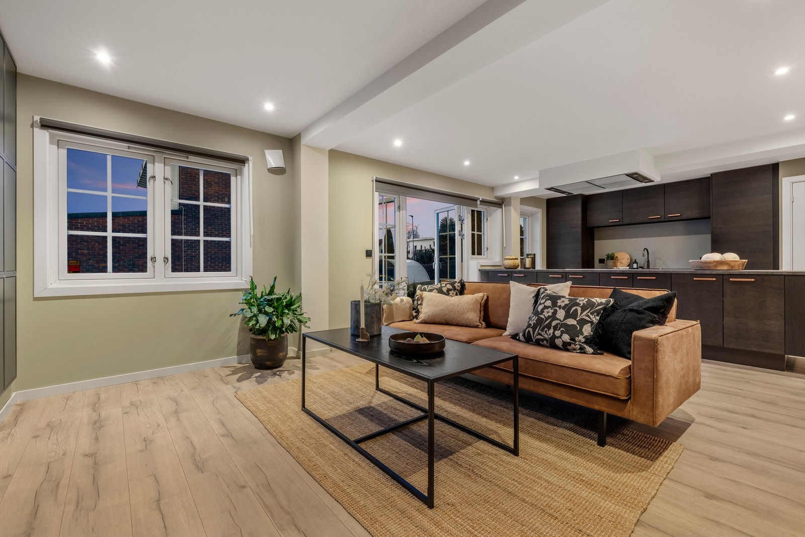 Et stilrent og moderne oppholdsrom med åpen planløsning mellom stue og kjøkken. Galleribilde