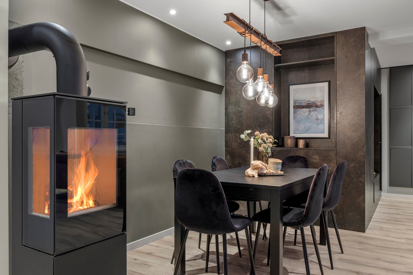 En lun og stilfull spiseplass med en moderne peisovn som skaper en hyggelig atmosfære. Galleribilde