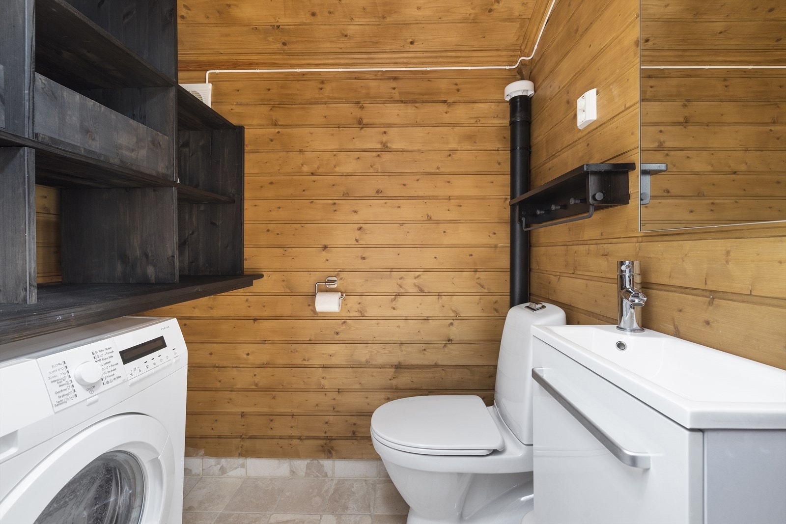 Vaskerom er innredet med servant, gulvstående toalett og opplegg for vaskemaskin. Galleribilde