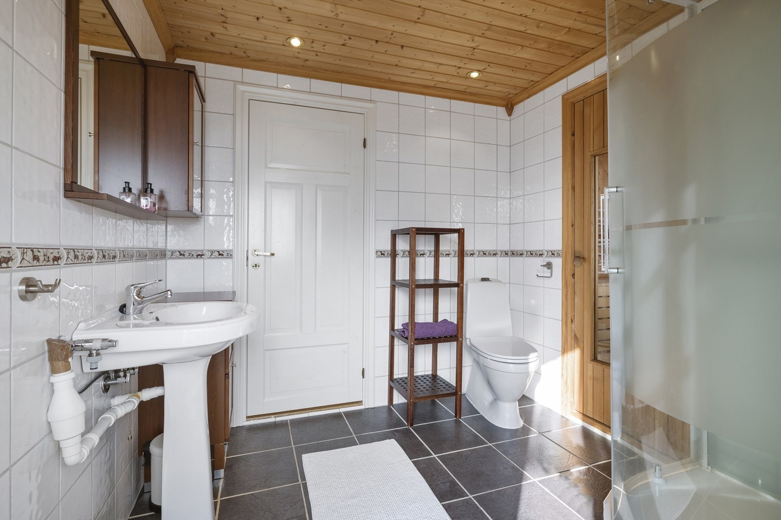 Bad 1 er innredet med servant, gulvstående toalett, dusjkabinett og har inngang til badstue. Galleribilde