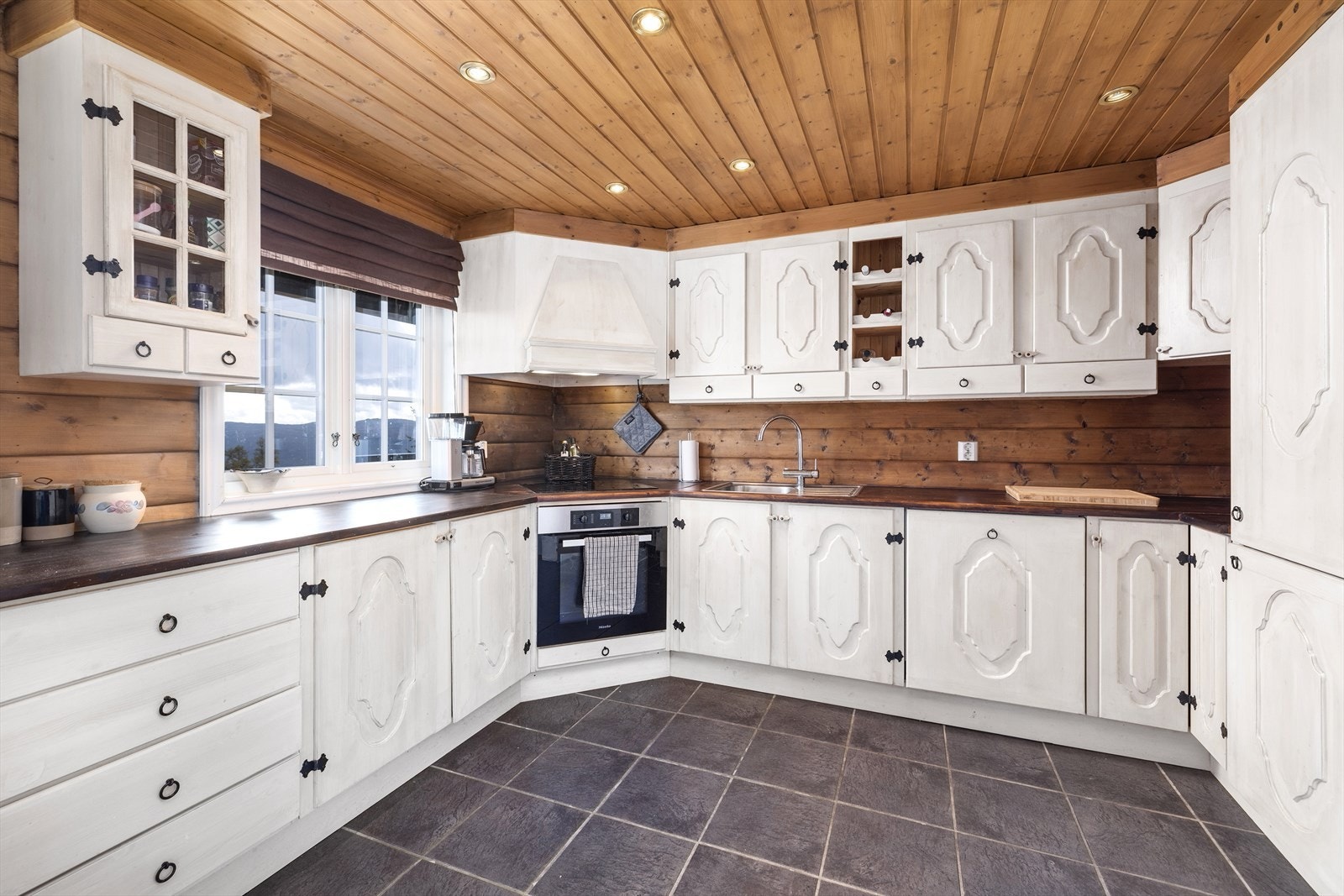 Kjøkken med profilerte og malte fronter og heltre benkeplate. Galleribilde