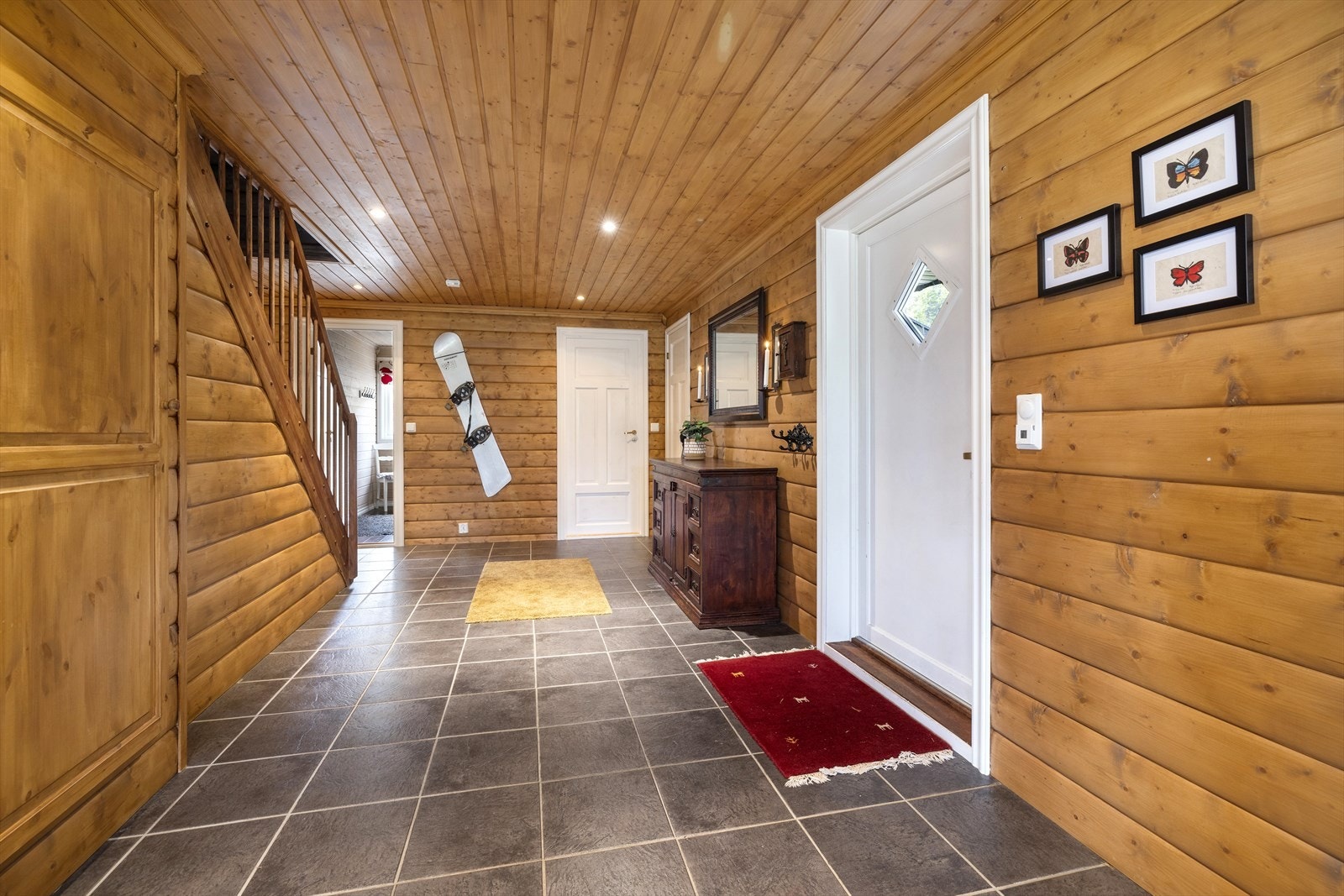 Stor hall med fliser på gulv og panel på vegger. Galleribilde