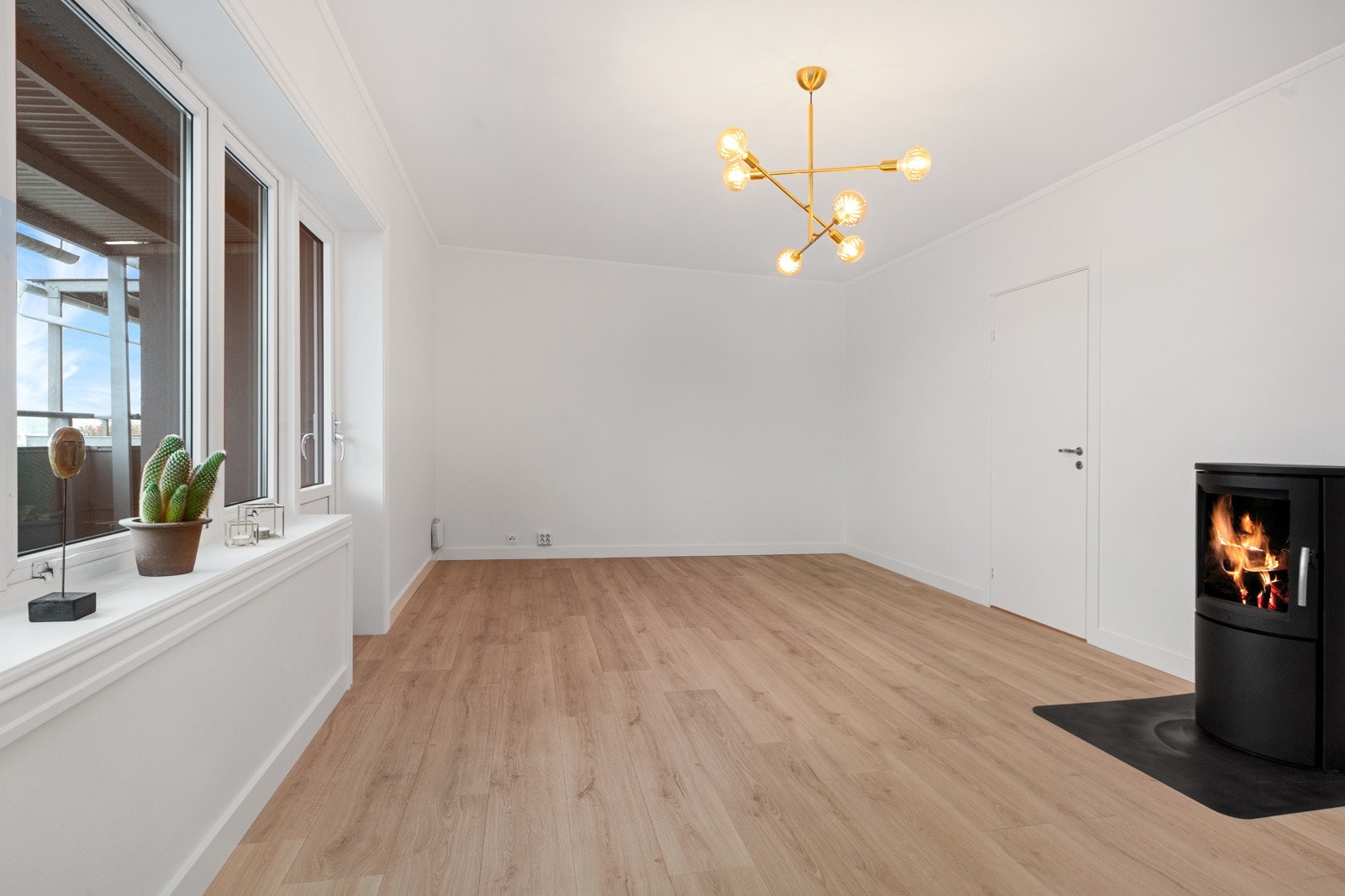 Flott lys stue med sentralt plassert vedovn Galleribilde