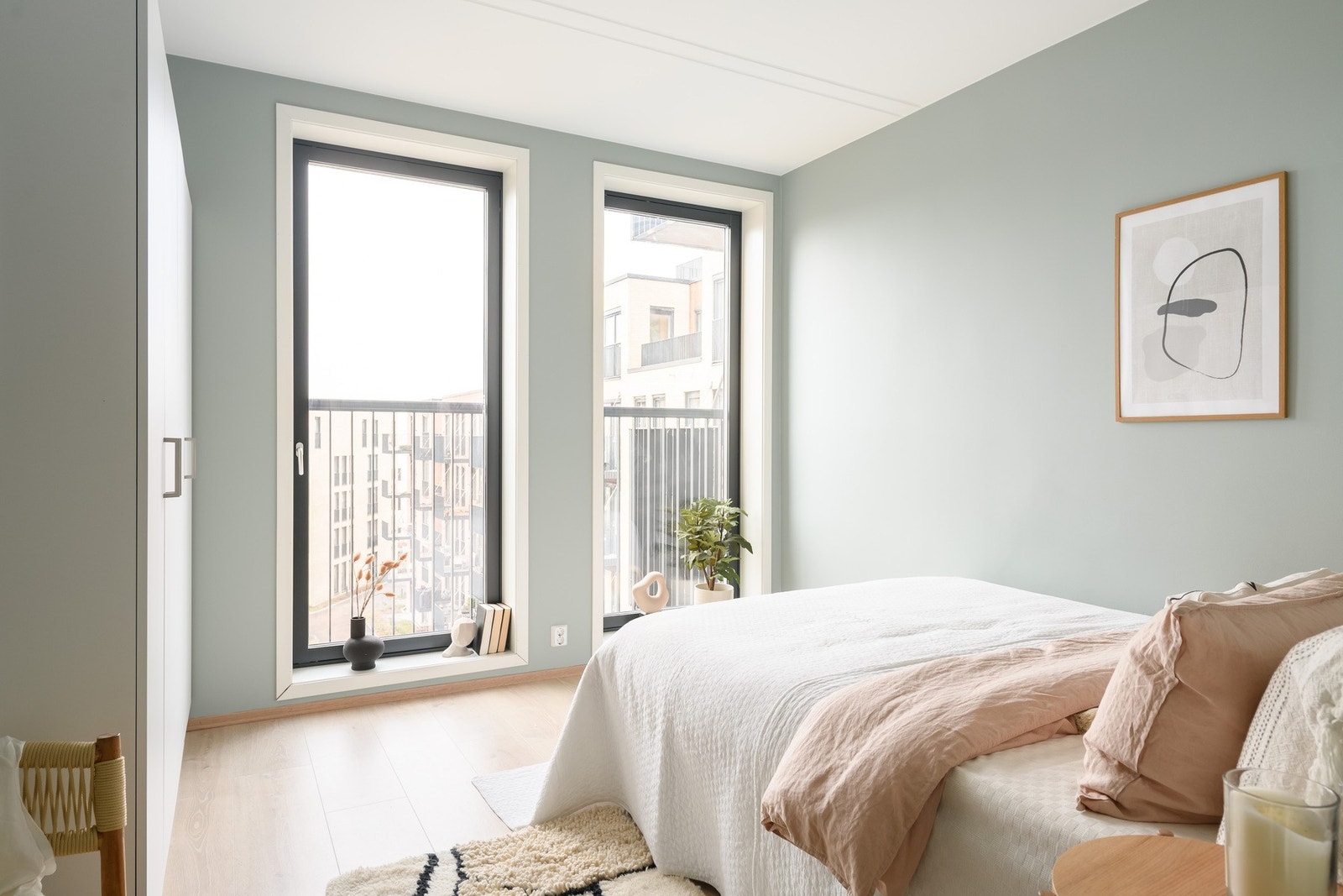 Det luftige soverommet bades i dagslys fra en fransk balkong med to høye vinduer helt ned til gulvet. Galleribilde