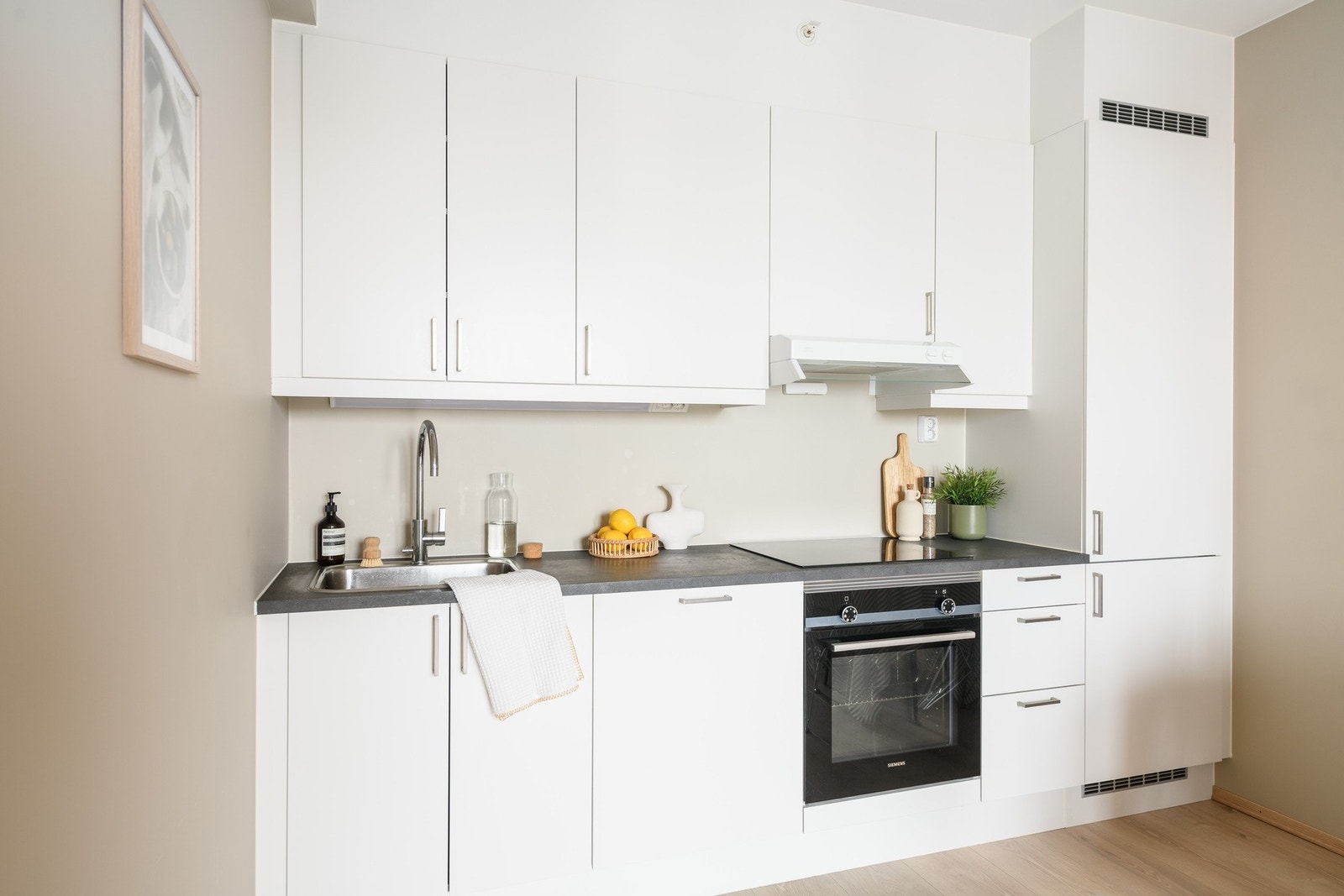 Kjøkkenet ligger pent bygd inn i åpen løsning med stuen og har alle hvitevarer integrert. Galleribilde