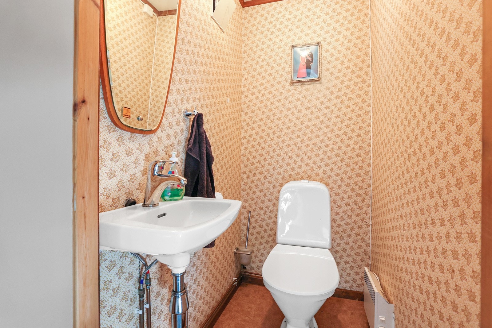 Toalettrommet har en enkel innredning med servant og gulvstående toalett. Galleribilde