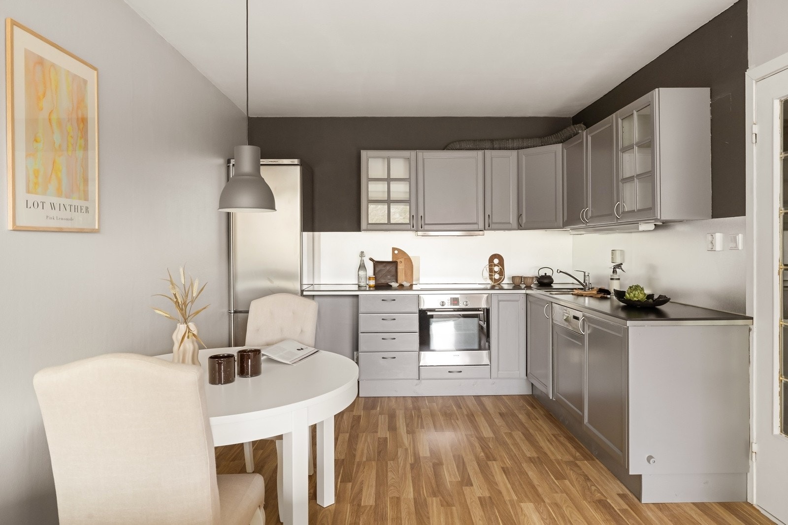 Kjøkkeninnredningen fra IKEA har en pen og tidløs fremtoning med gråmalte, profilerte fronter, vitrineskap og sort benkeplate i fin kontrast. Galleribilde