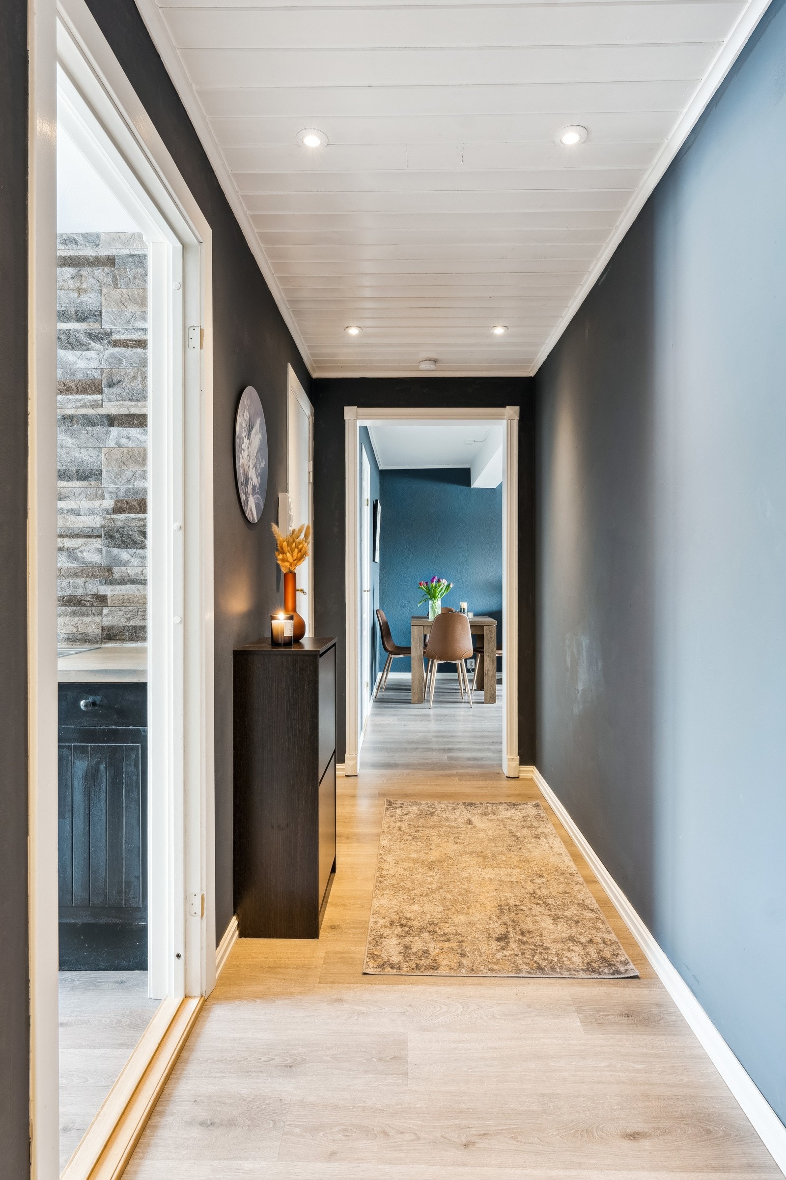 Romslig entré med god plass til garderobe. Dørcalling. Et fint rom til å ønske venner og familie velkommen. Galleribilde