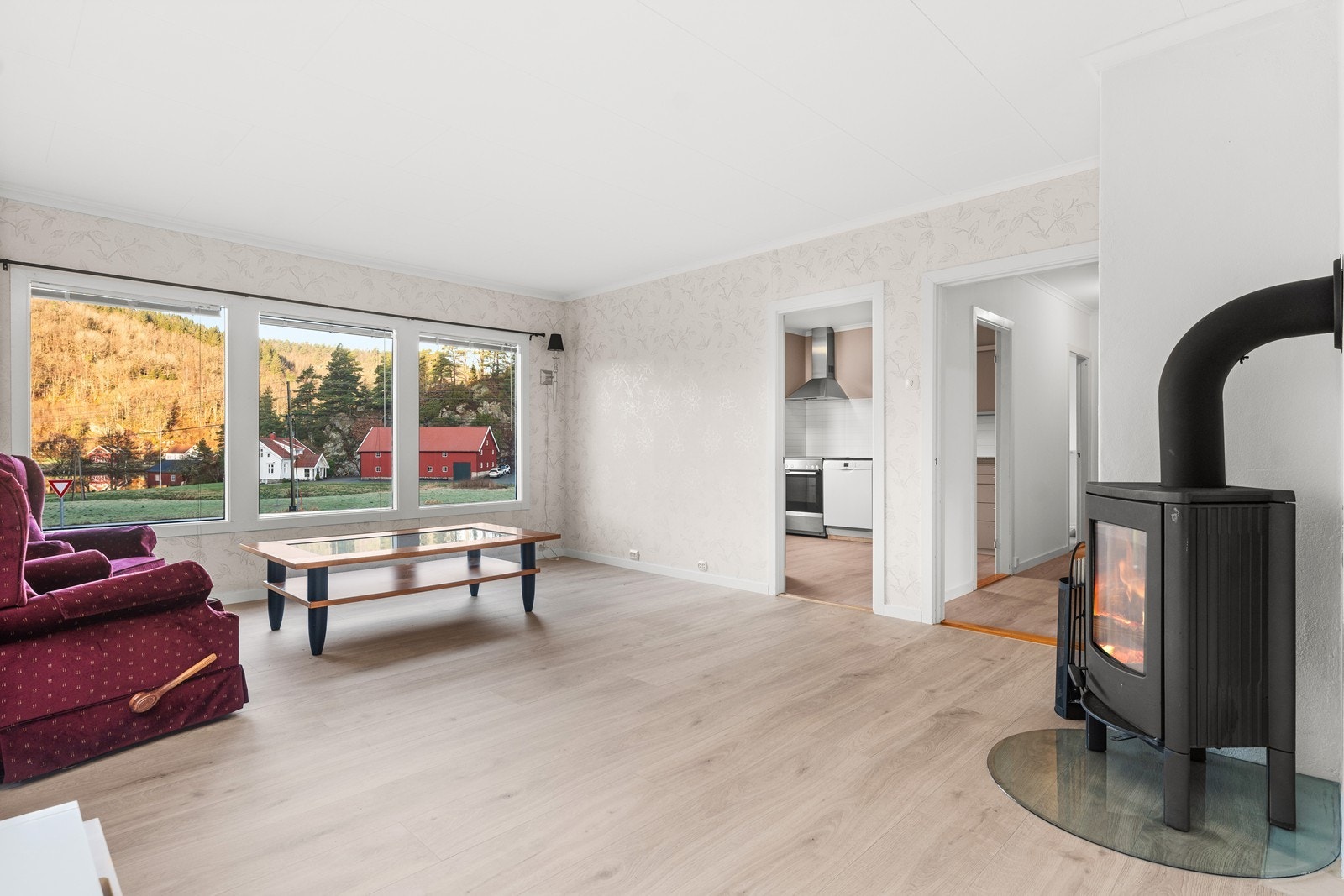 Romslig stue med store vinduer og vedovn. Overflatene er nylig pusset opp. Galleribilde
