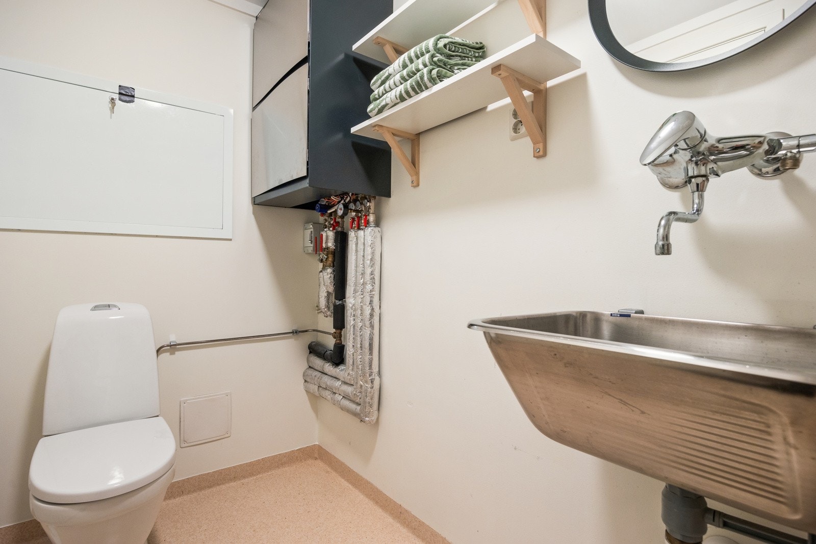 Vaskerommet er innredet med belegg på gulv, og utstyrt med opplegg for vaskemaskin, utslagsvask, toalett og hyller til oppbevaring. Galleribilde