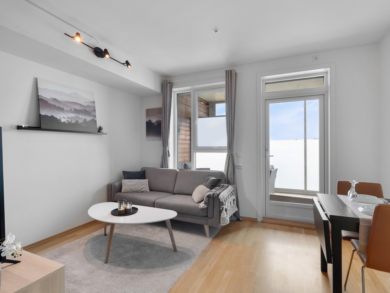 Romslig stue med med store vindusflater som slipper inn rikelig med naturlig dagslys. Galleribilde