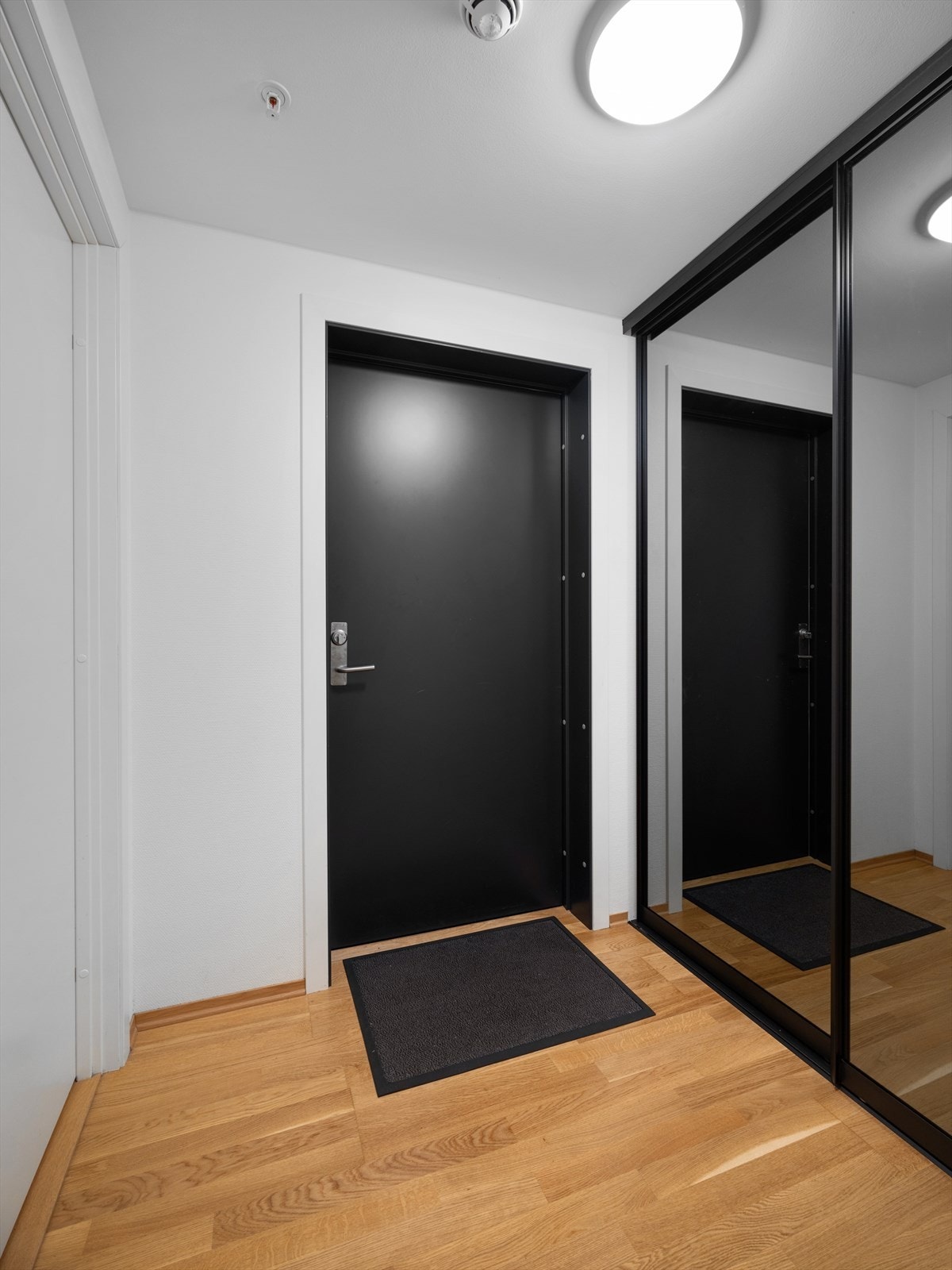 Lys og innbydende entré med moderne detaljer og plass til yttertøy i skyvedørsgarderobe. Galleribilde