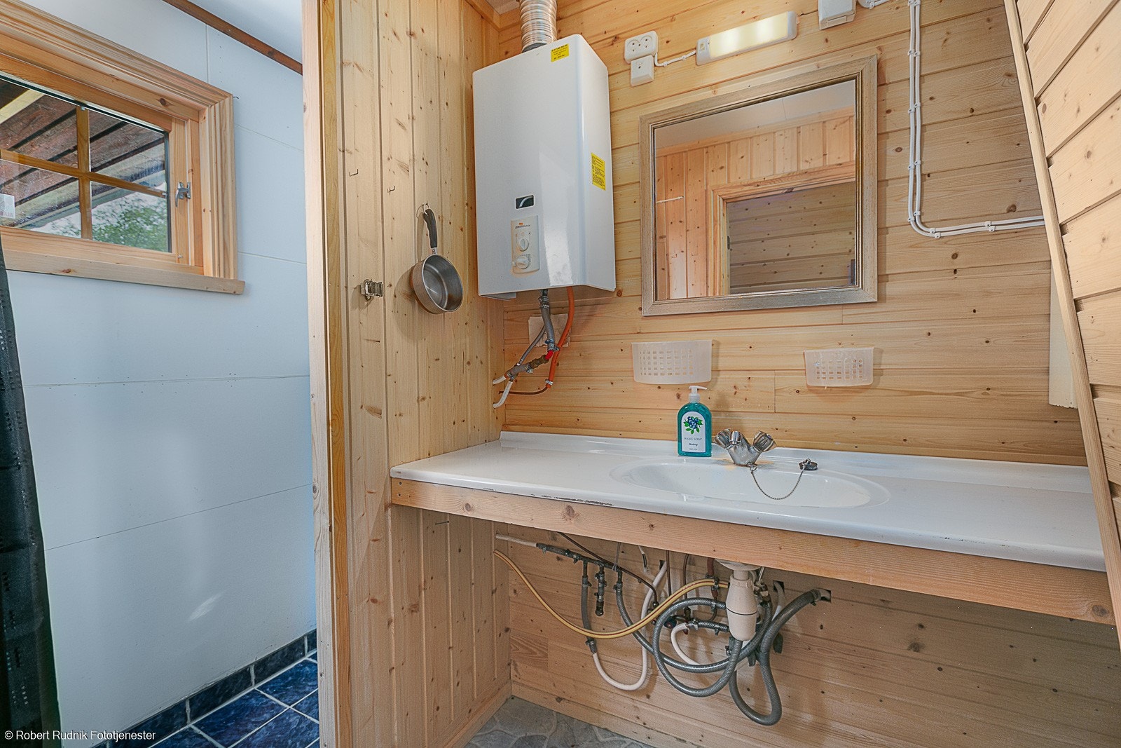 Bad med dusjnisje og servant. Hytta har sommervann og varmtvannsbereder som går på gass. Galleribilde