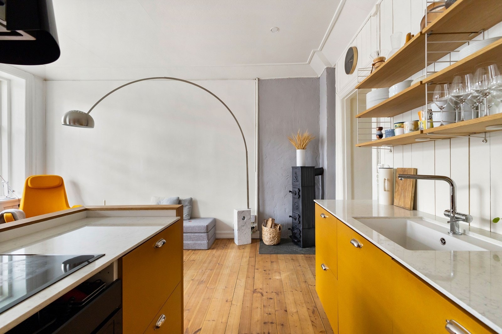 Kjøkkeninnredning med glatte fronter og benkeplate i stein med nedfelt vaskekum. Galleribilde