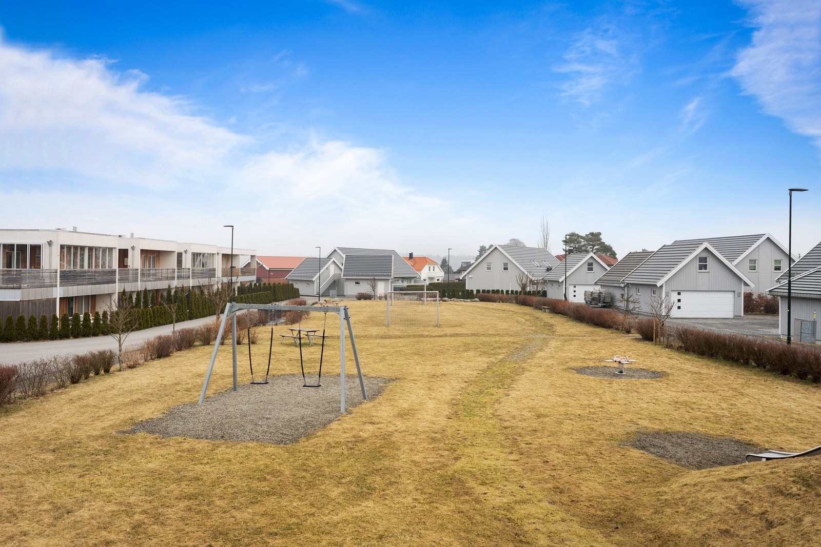 Bygget ligger i et barnevennlig nabolag med store, grønne fellesarealer, lekeplass, benker og bord. Galleribilde