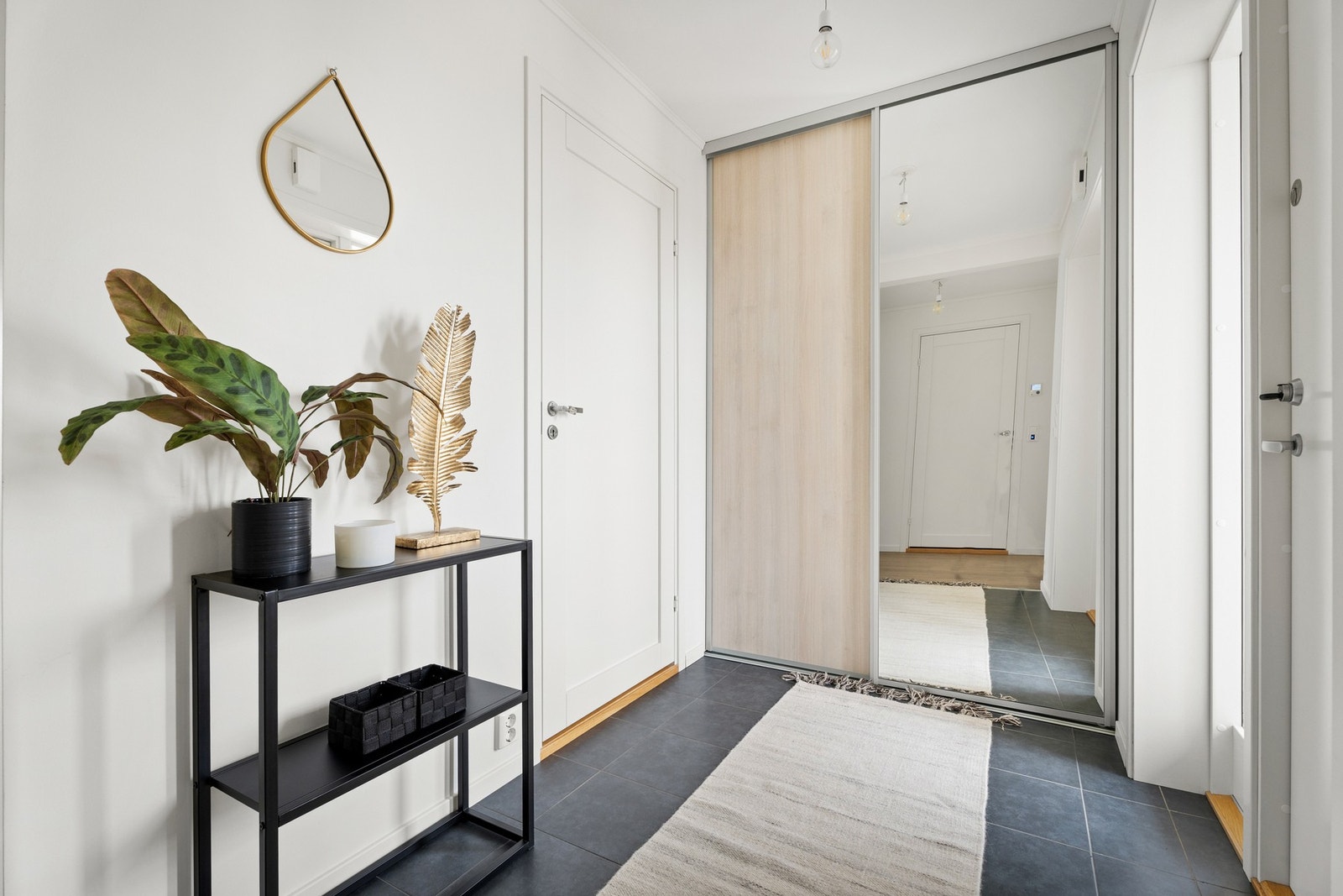 Entreen er smart innredet med en skyvedørsgarderobe som har eikelaminart front og speilfront. Galleribilde