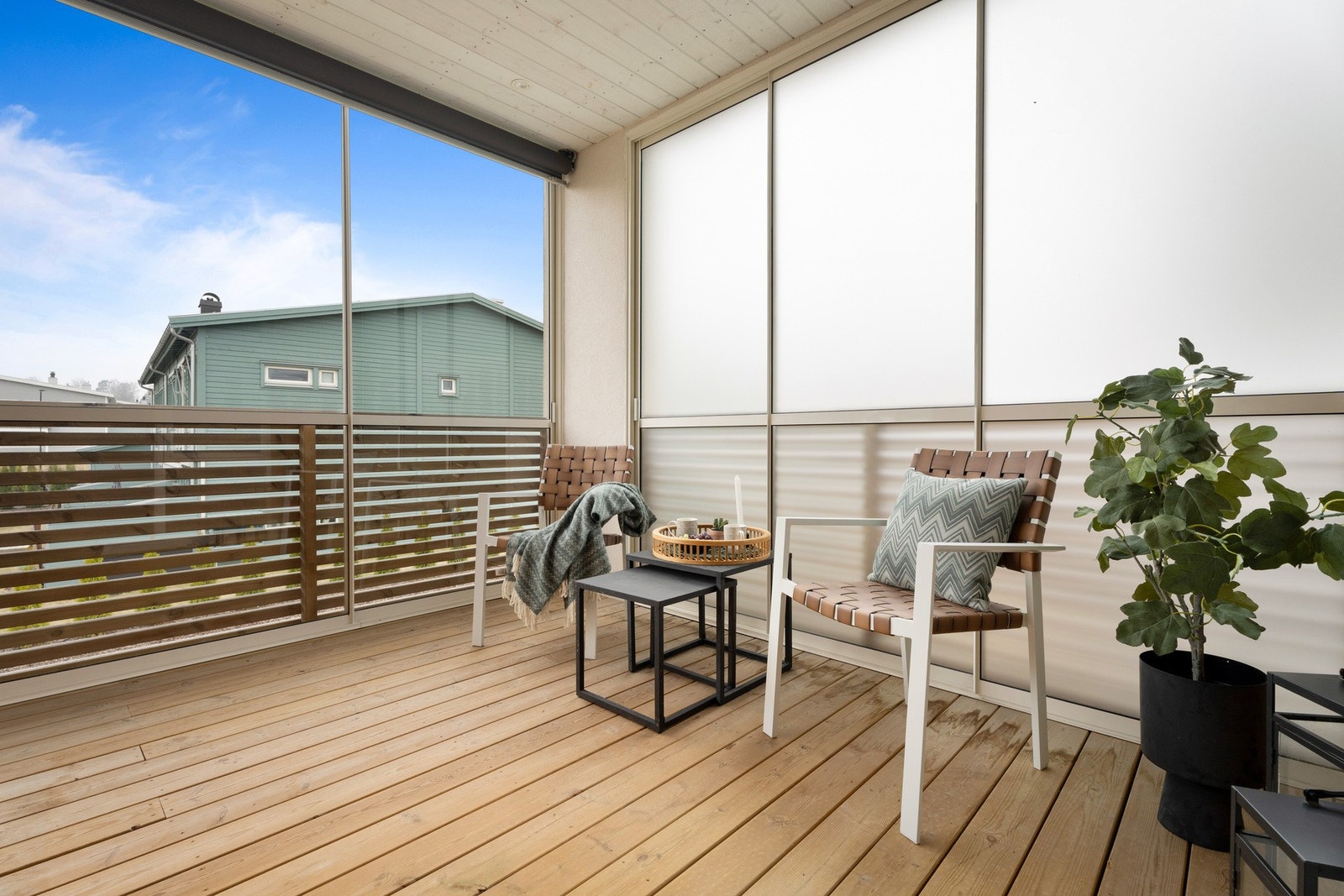 Skyvedørene på siden har frostet glass, dekket er av terrassebord, himlingen er i hvitmalt panel, mens husveggen er kledd i panel med en varm glød som skaper lun stemning. Galleribilde