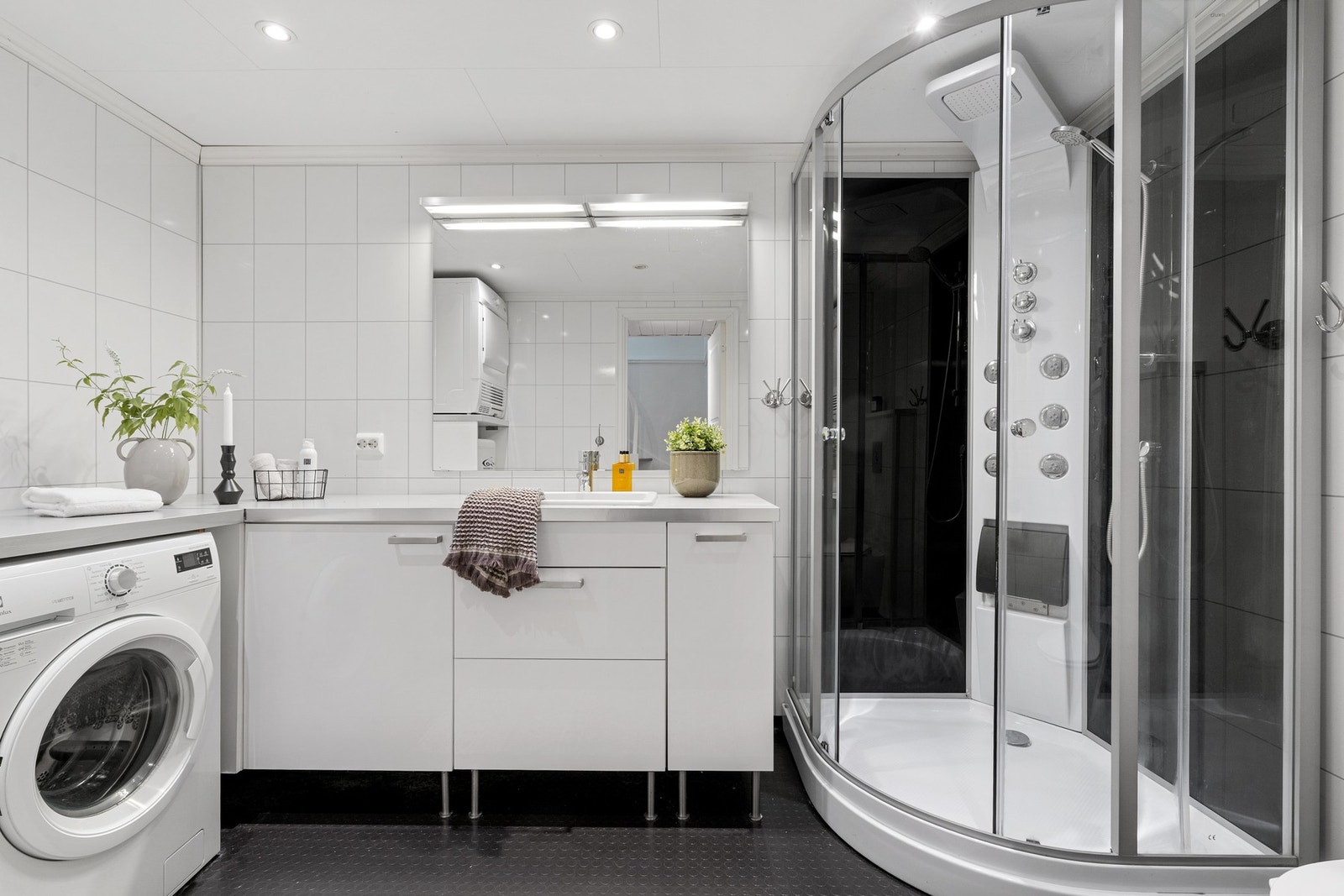 Badet i under etasjen er innredet med vaskemaskin, tørketrommel og dusjkabinett. Galleribilde