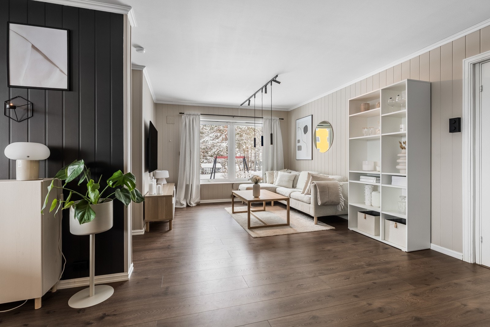 Stuegulvet har mørkt 1-stavs laminat, som står godt til panelplater malt i sort og en delikat grånyanse. Galleribilde