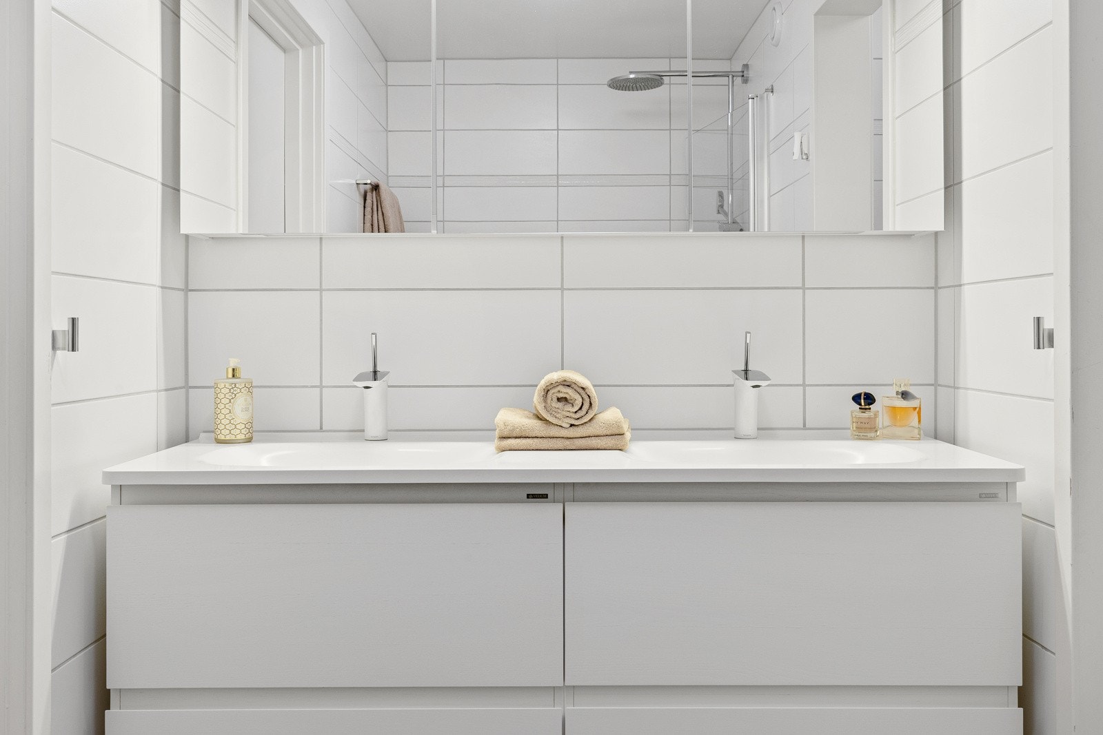 Badet har en Wedum innredning fra fra 2011 og er utstyrt med to nedfelte servanter, veggmontert toalett, dusjhjørne med glassvegger. Servantinnredningen består av 4 romslige skuffer og 3 overskap med speildører. Galleribilde