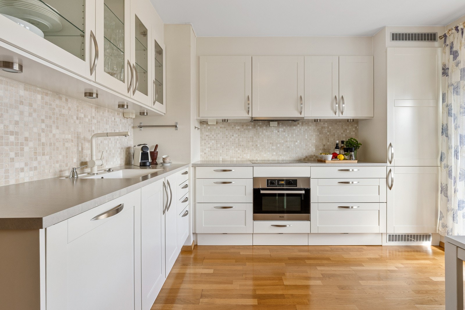 Kjøkkenet har profilerte fronter og en solid laminatbenkeplate med planlimt oppvaskkum og uttrekkskran Galleribilde