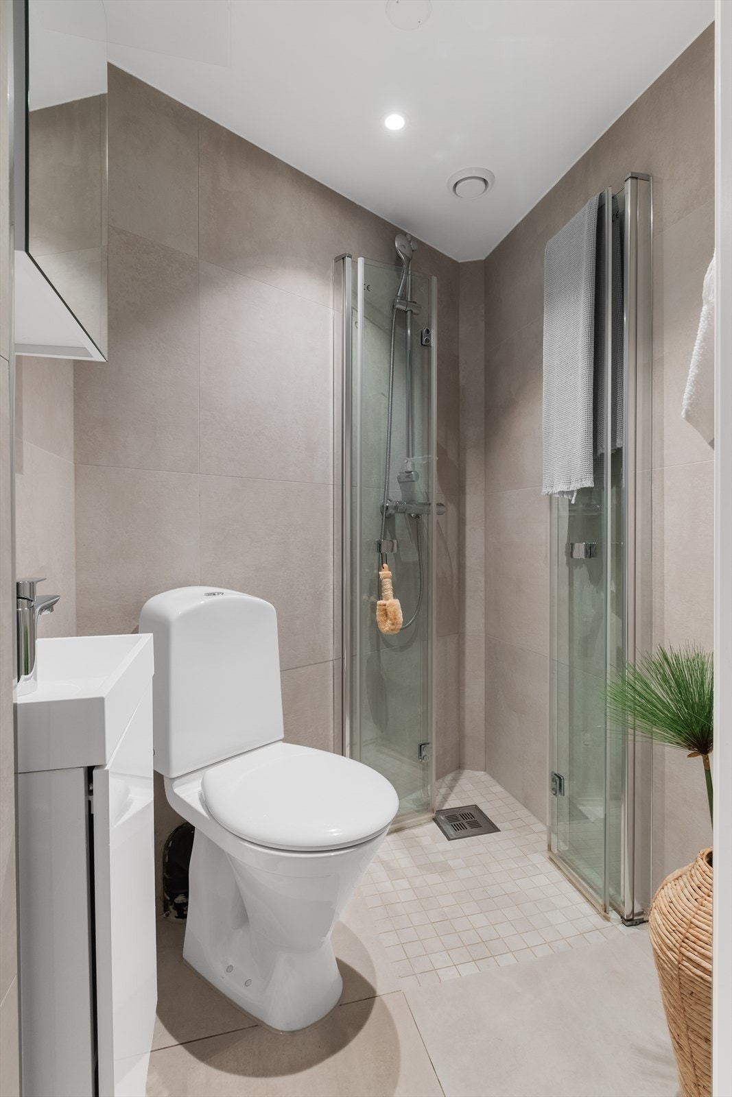 Flislagt bad med servantinnredning med underskap, veggmontert speilskap, wc, dusj med foldbare dusjvegger, opplegg for vaskemaskin. Varmekabler i gulv. Galleribilde