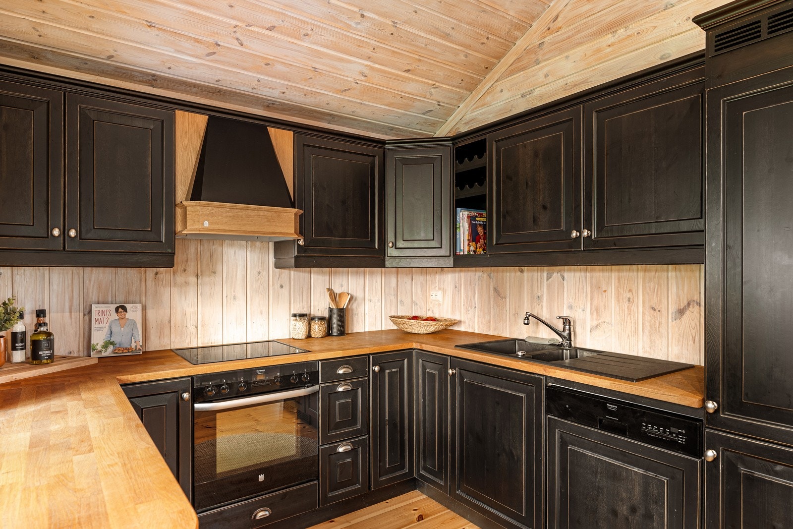 Selve kjøkkeninnredningen er trukket vekk fra stuen og formet i hestesko, slik at flere kan være med om å lage mat. Galleribilde