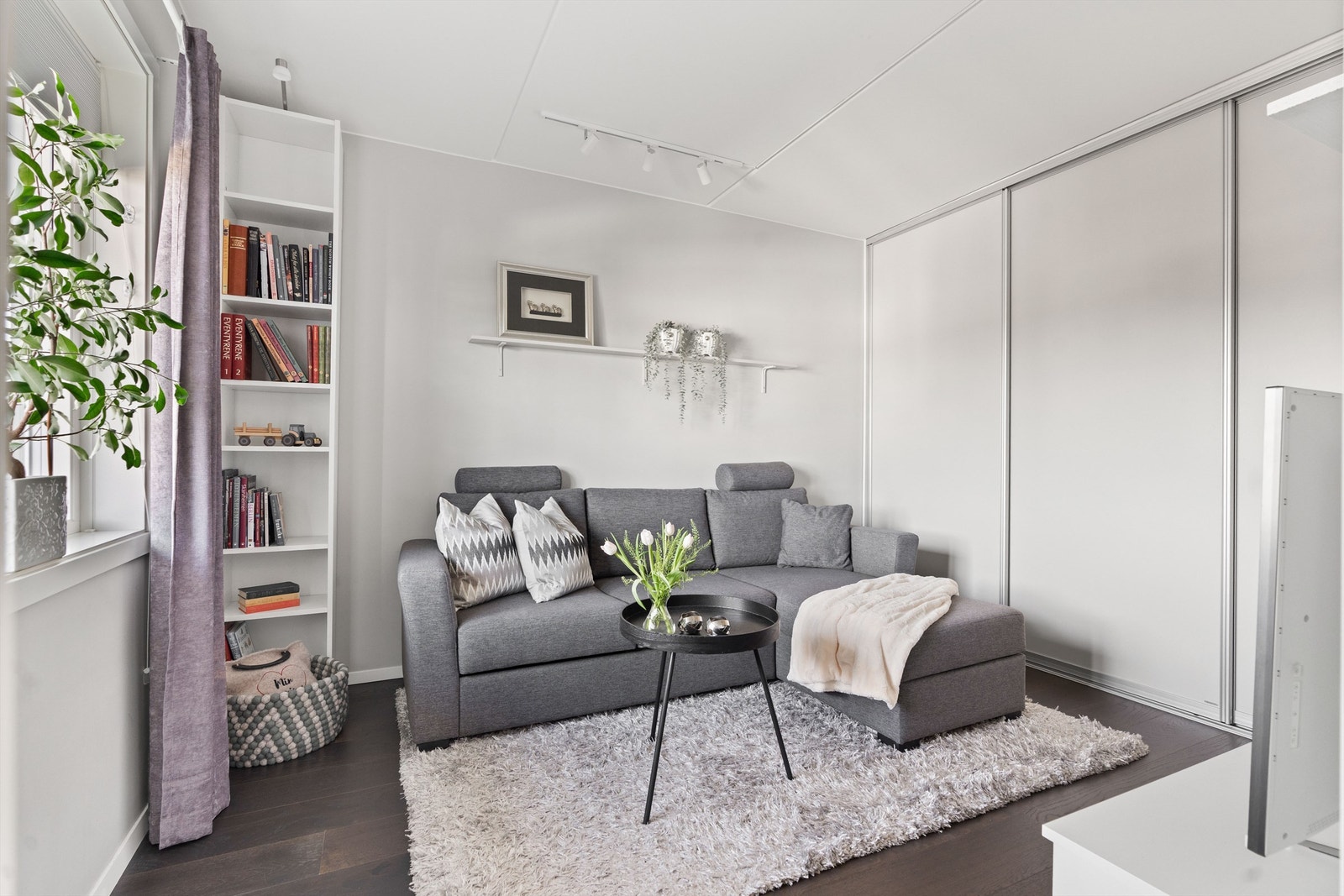 Soverom 2 med praktisk skyvedørsgarderobe. Soverommet er i dag innredet som TV-stue med sovesofa som enkelt gjør rommet fleksibelt. Galleribilde