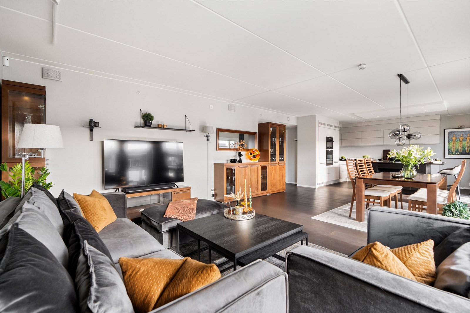 Stue og kjøkken er i en åpen og moderne løsning. Kjøkkeninnredning er i samme farge som vegger og gir et helhetlig og diskret inntrykk Galleribilde