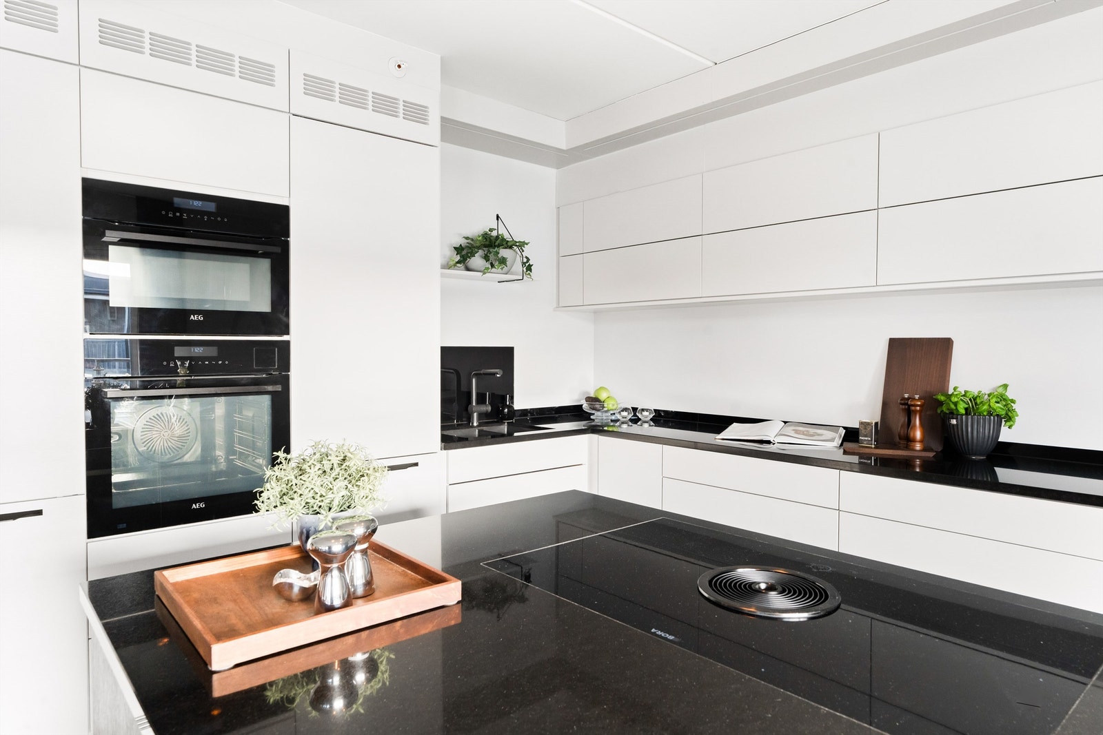 Integrerte hvitevarer som oppvaskmaskin, kjøleskap, vinskap, induksjonstopp med integrert avtrekk, dampovn og kombinert steke-/ microovn Galleribilde