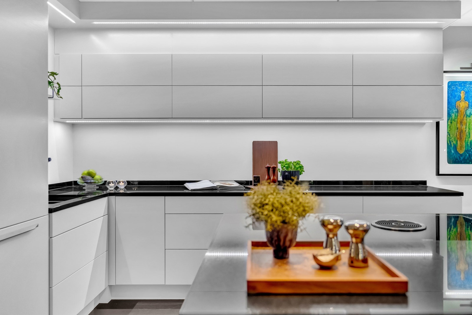 Nedfelt ventilator i kjøkkenøyen med induksjonstopp. Sort polert granitt benkeplate. Galleribilde