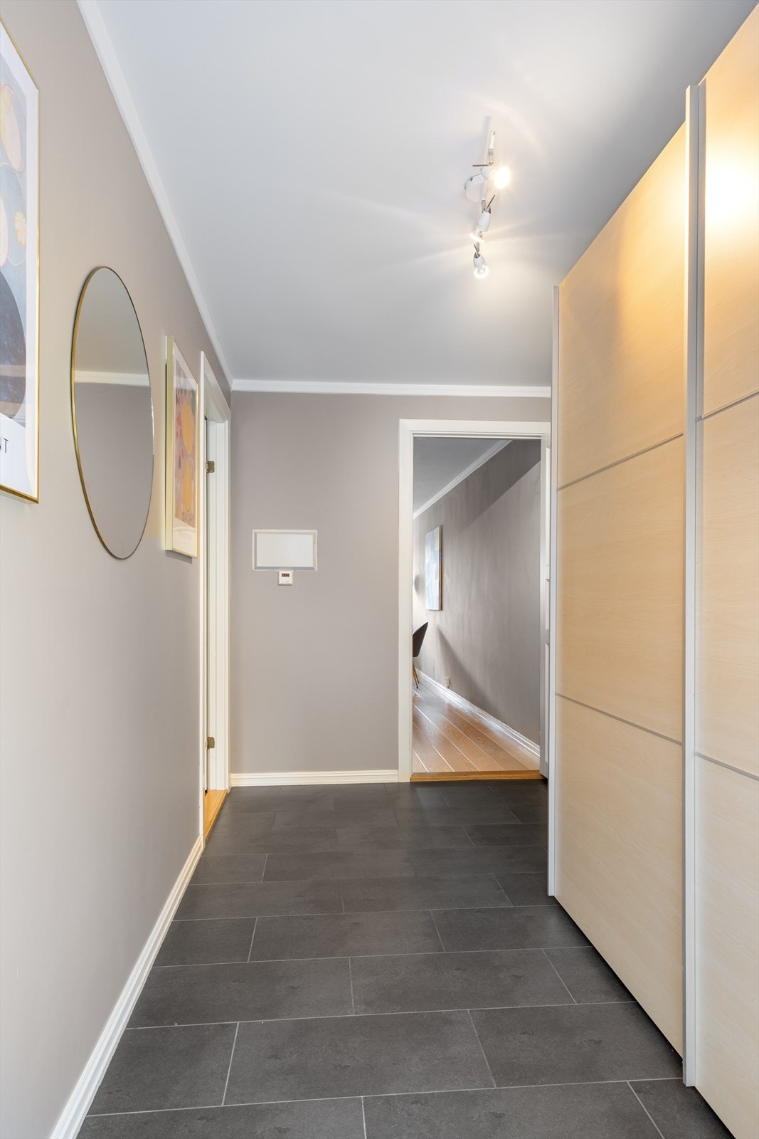 Entréen er en praktisk og lys sone med flislagt gulv og malte vegger. Galleribilde