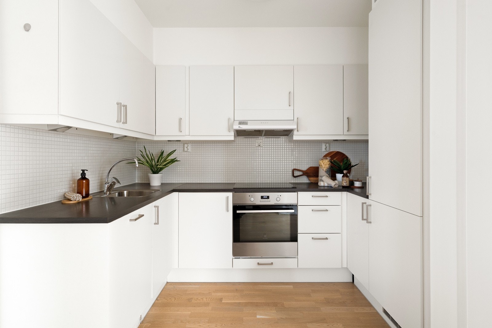 Lyst og pent kjøkken med integrerte hvitevarer. Galleribilde