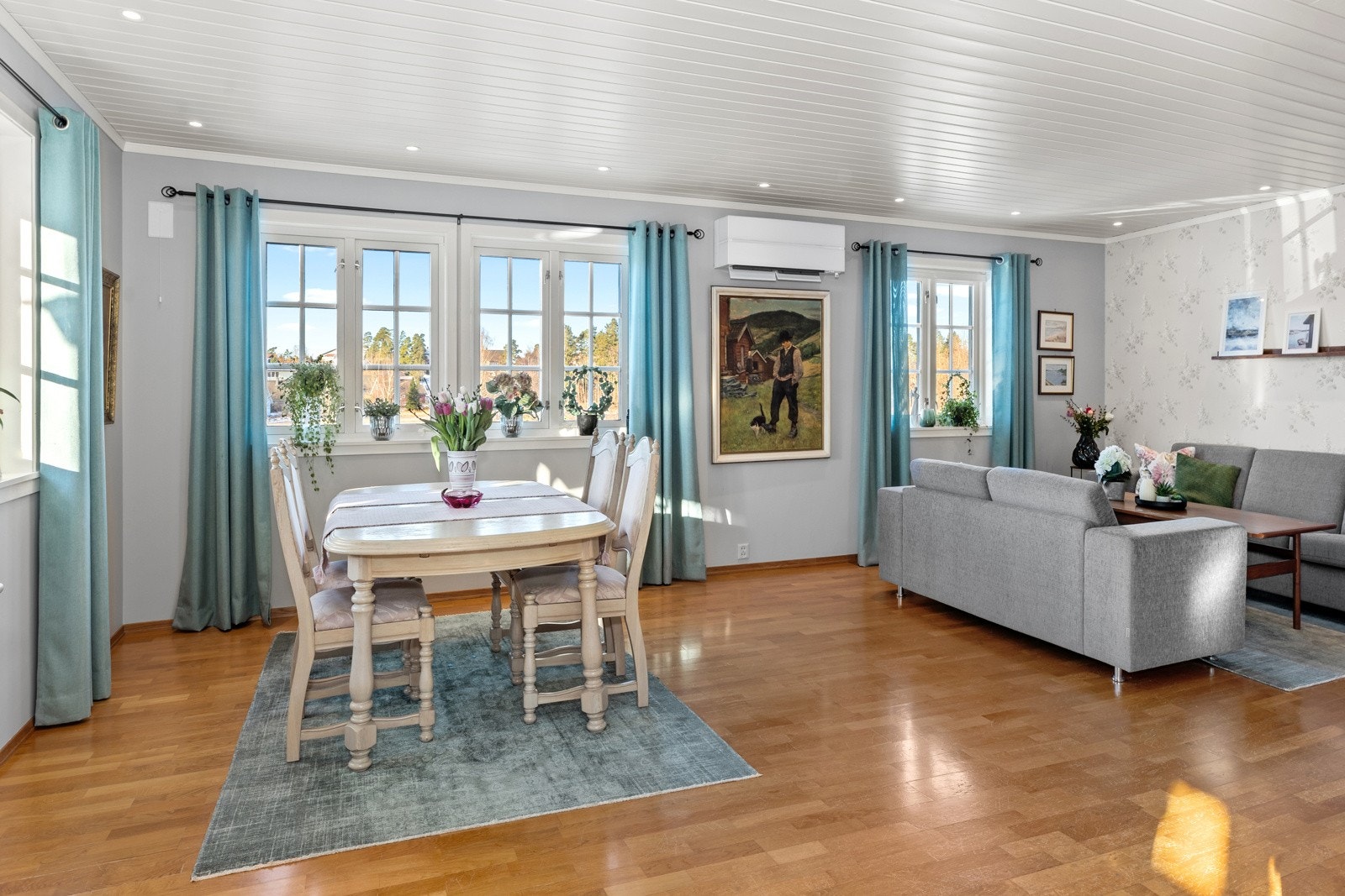 Her er det plass til både stor sofagruppe og spisebord, og store vindusflater slipper inn rikelig med naturlig lys, som skaper en lys og innbydende atmosfære. Galleribilde