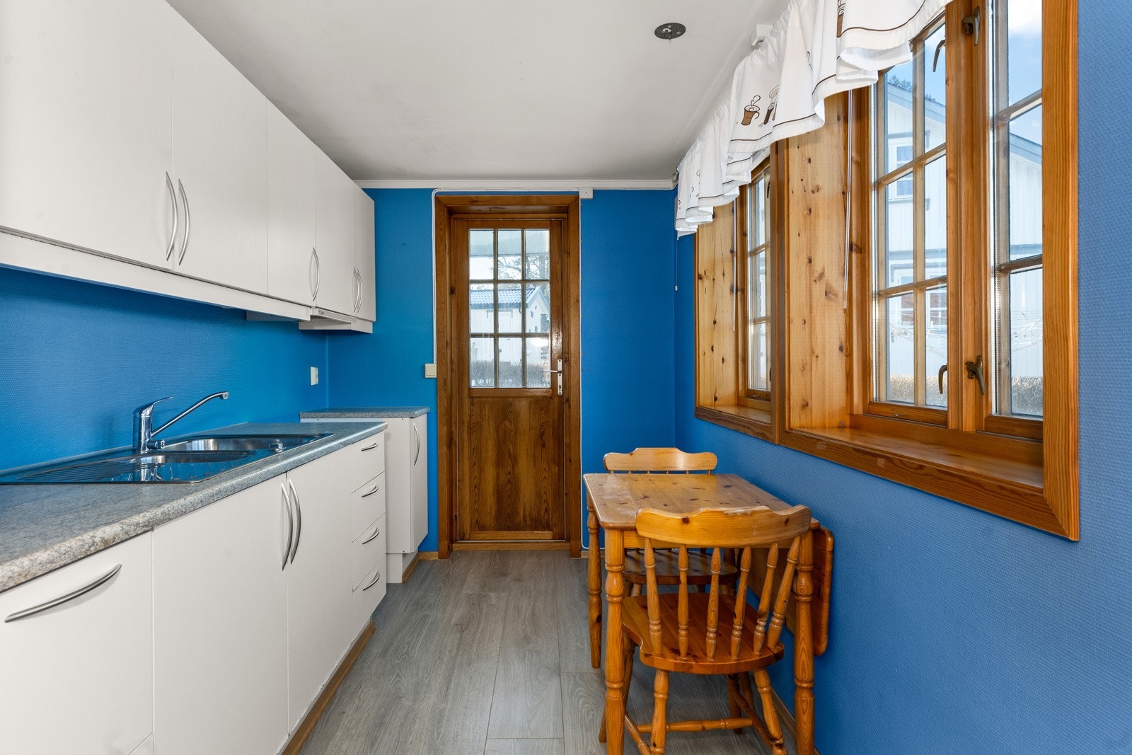 Kjøkkeninnredning i utleiedel fra 2000. Kjøkkenet har slette fronter, laminat benkeplate, samt frittstående komfyr og kjøleskap. Galleribilde