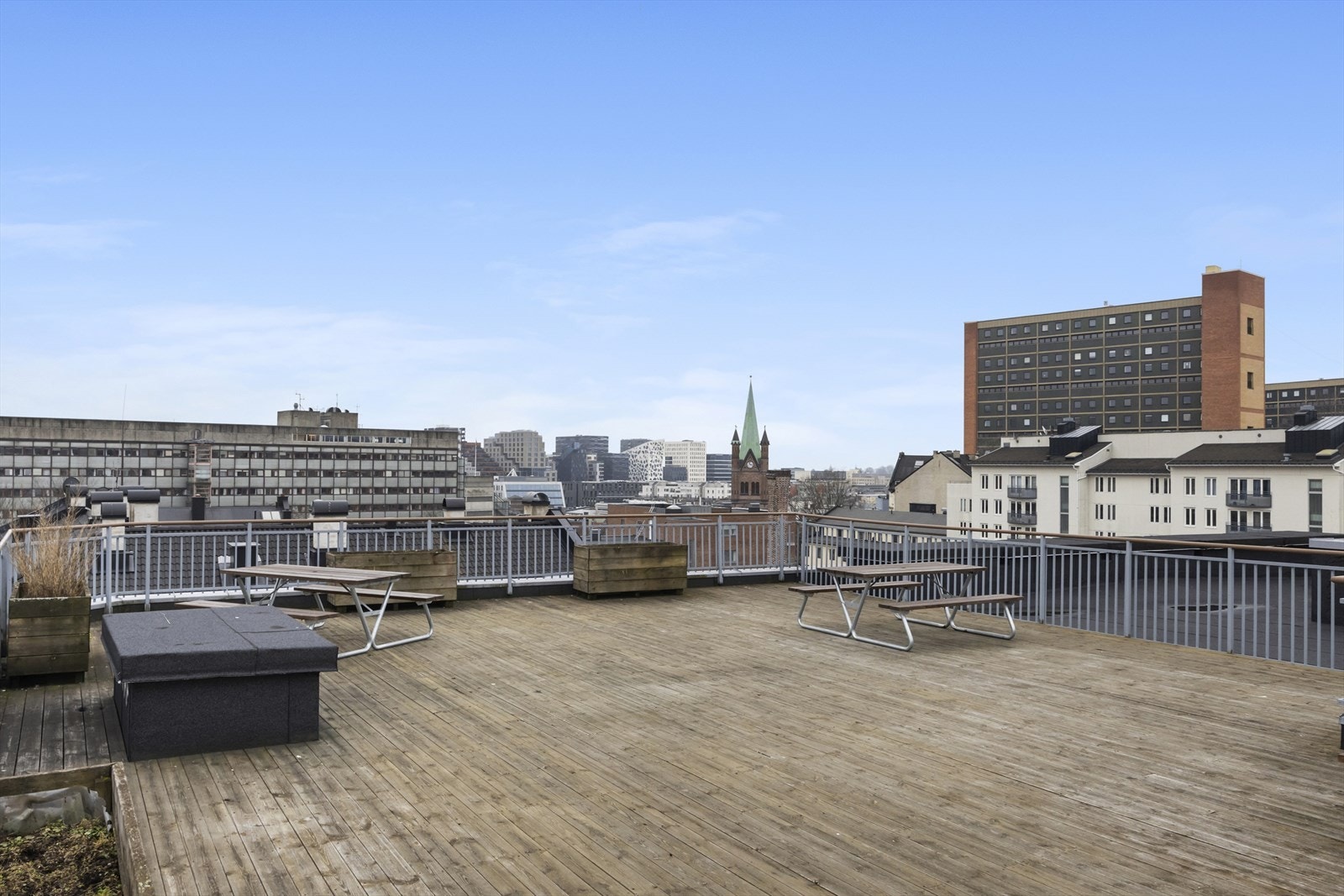 Flott, felles takterrasse med heisadkomst og utsikt utover hustakene og mot barcode Galleribilde