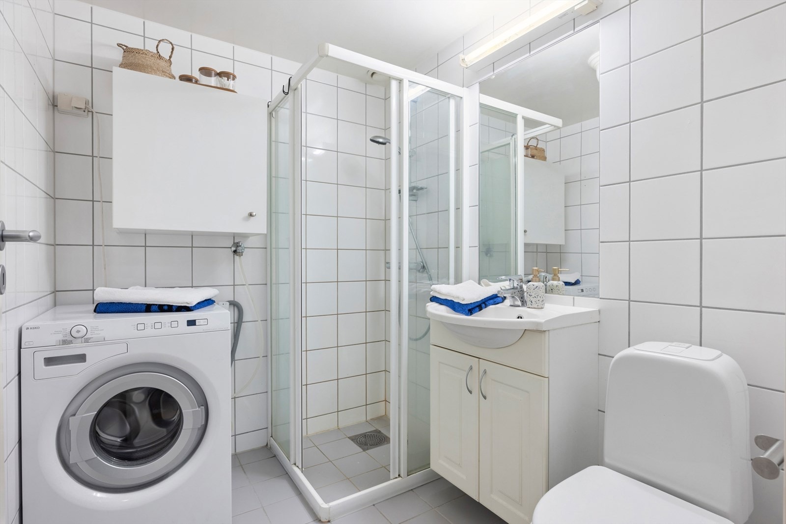 Lyst, flislagt bad med varmekabler og opplegg for vaskemaskin Galleribilde