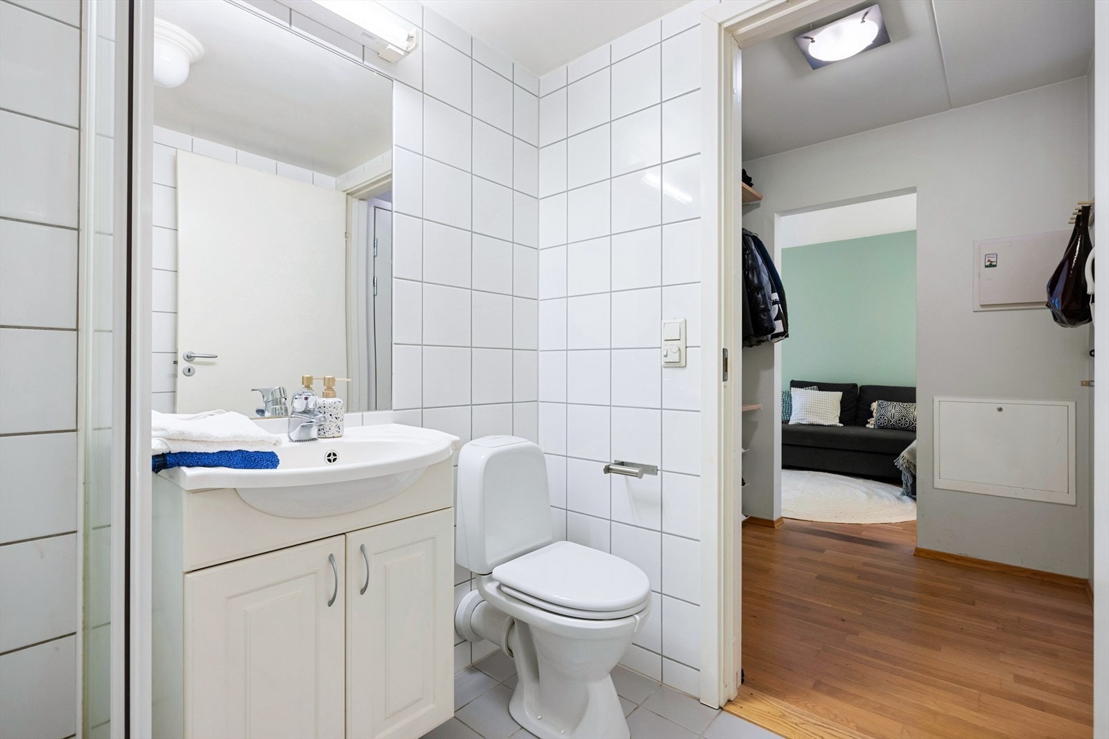 Innredet med toalett, servant med servantskap og dusjhjørne. Veggskap og speil Galleribilde