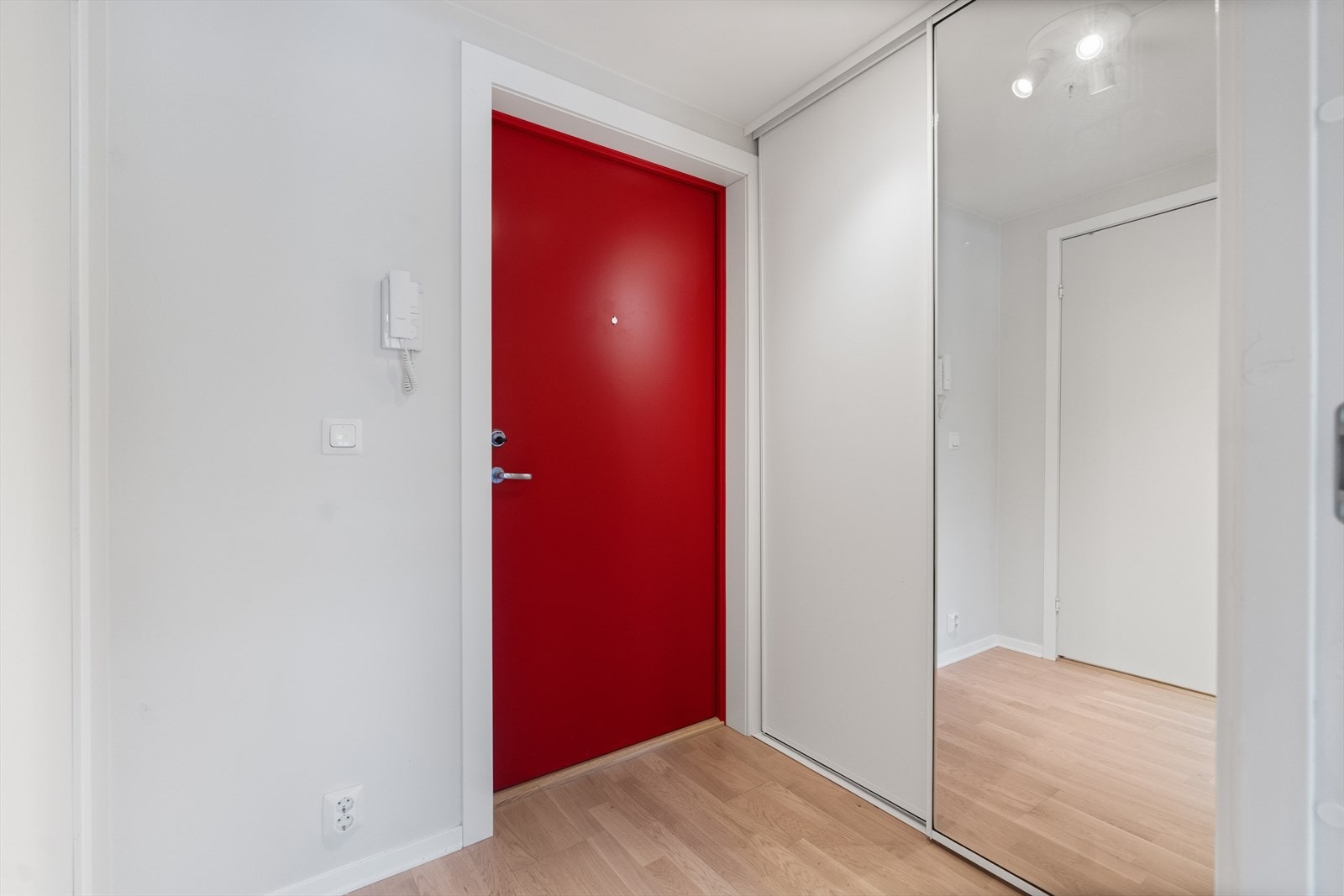 Leiligheten har en lys entré med mye lagringsplass i praktisk skyvedørsgarderobe med speilfronter. Galleribilde