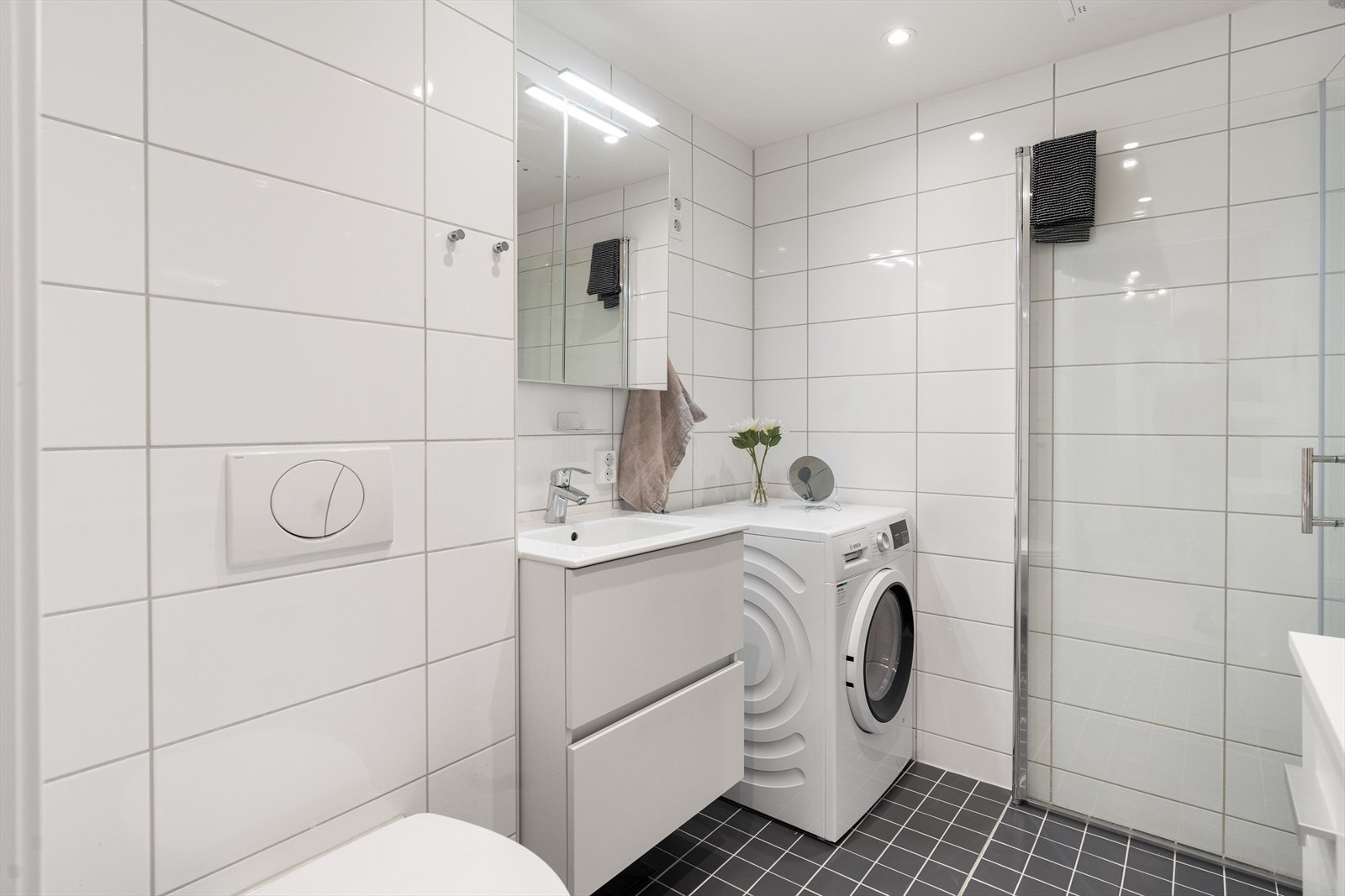 Rommet har servantskap med glatte, folierte fronter og heldekkende servant, samt et speilskap med lysarmatur. Galleribilde