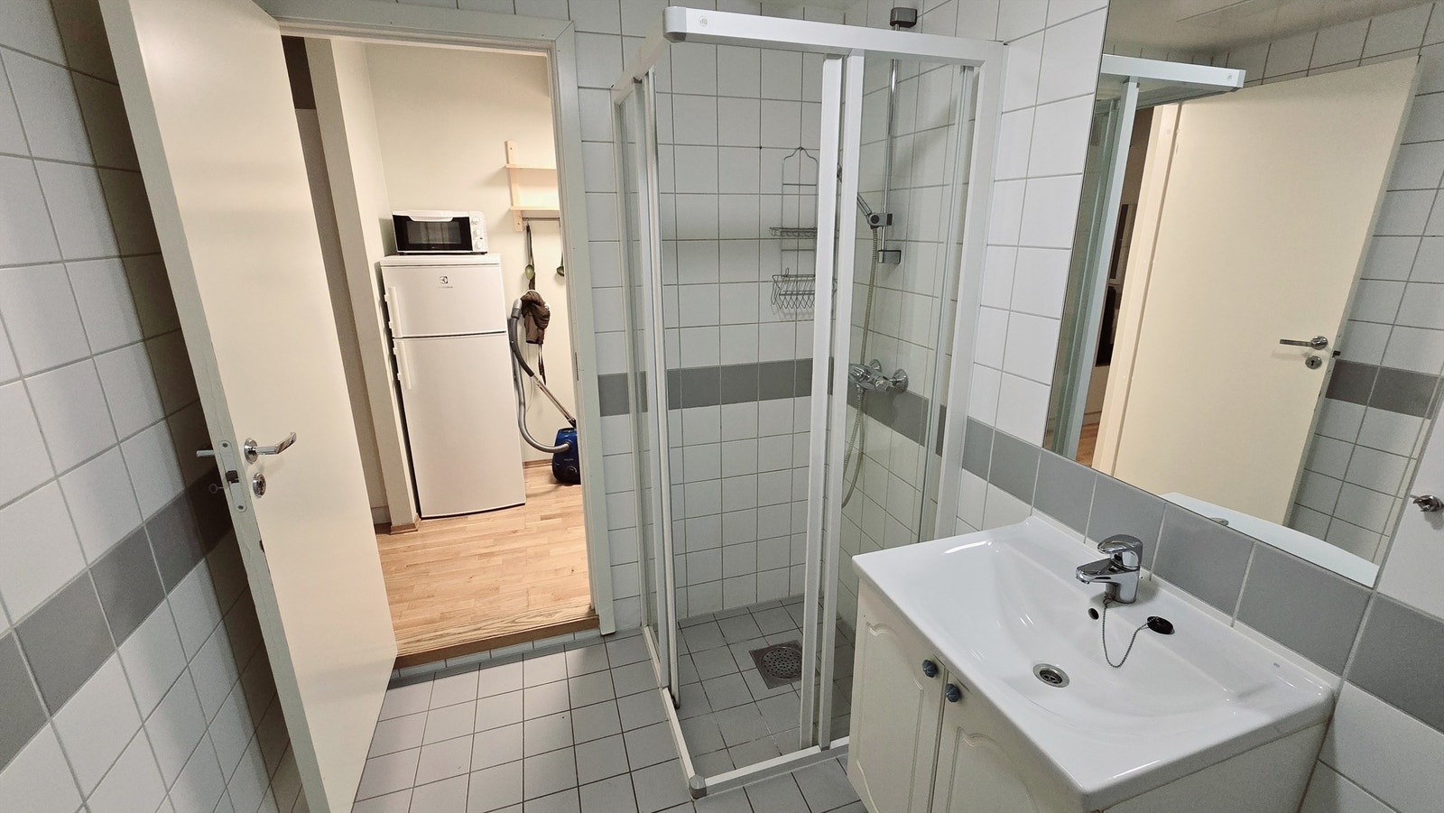 Lyst flislagt bad med oppbevaringsmuligheter. Galleribilde