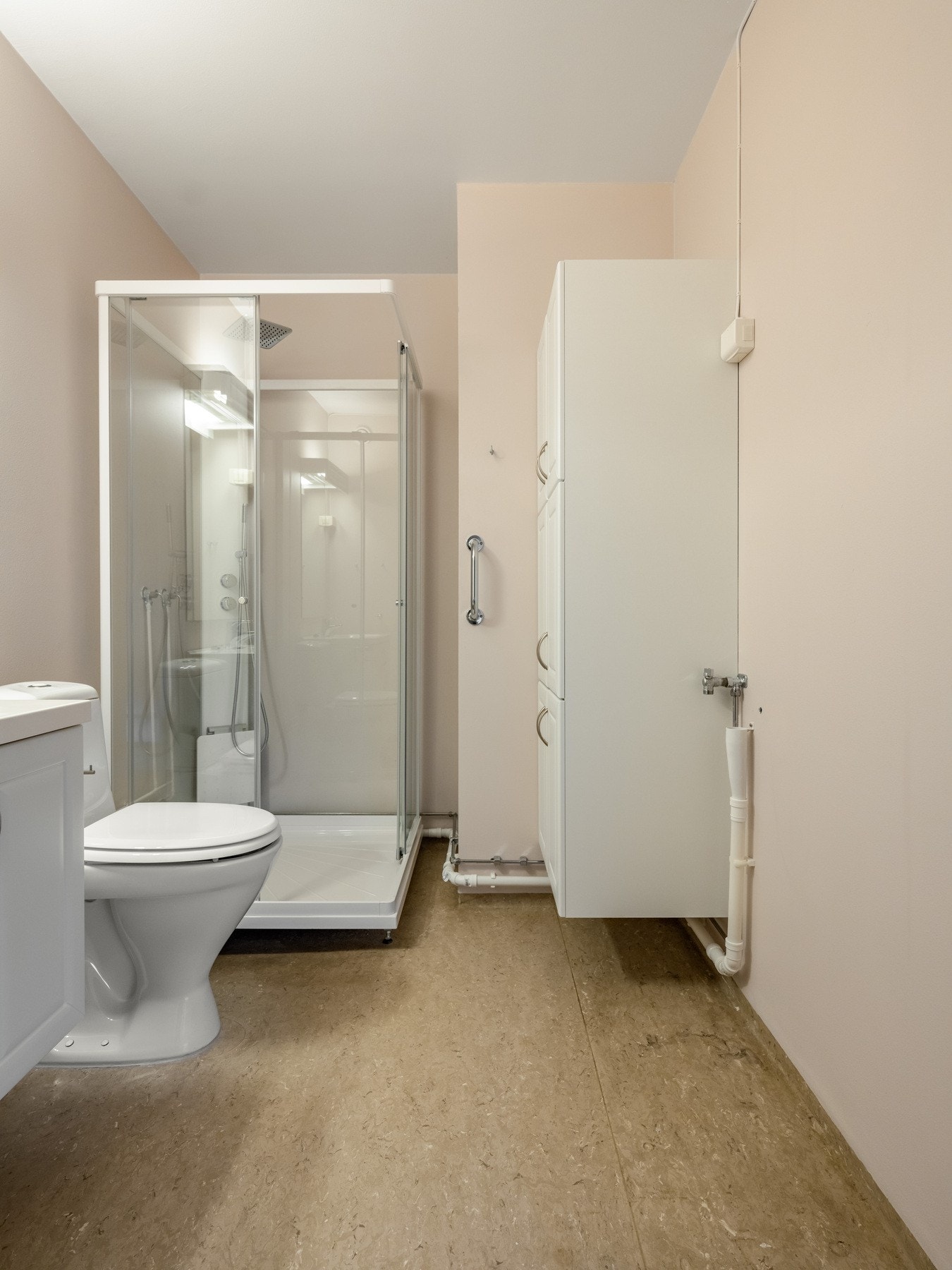 Badet er innredet med dusjkabinett, gulvstående toalett og servant. Galleribilde