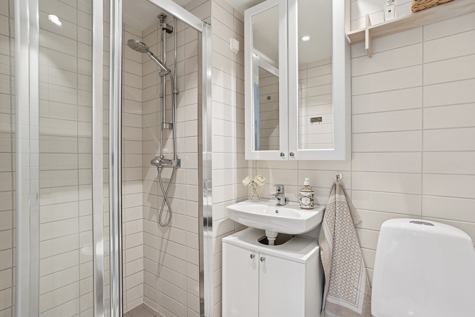 Baderomsinnredningen er bestående av servant med underskap, veggskap med speilfronter, gulvmontert klosett og dusjhjørne med skyvedør. Mekanisk avtrekk på bad. Galleribilde