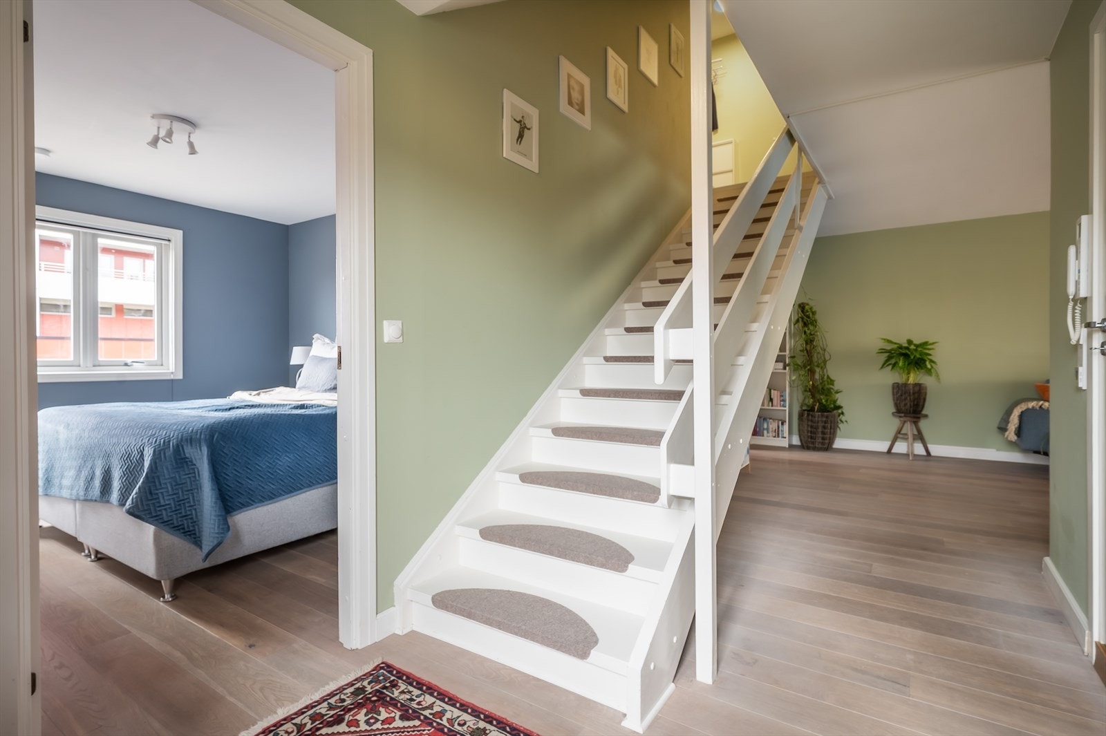 Leiligheten har en hvit tretrapp mellom etasjene. Galleribilde