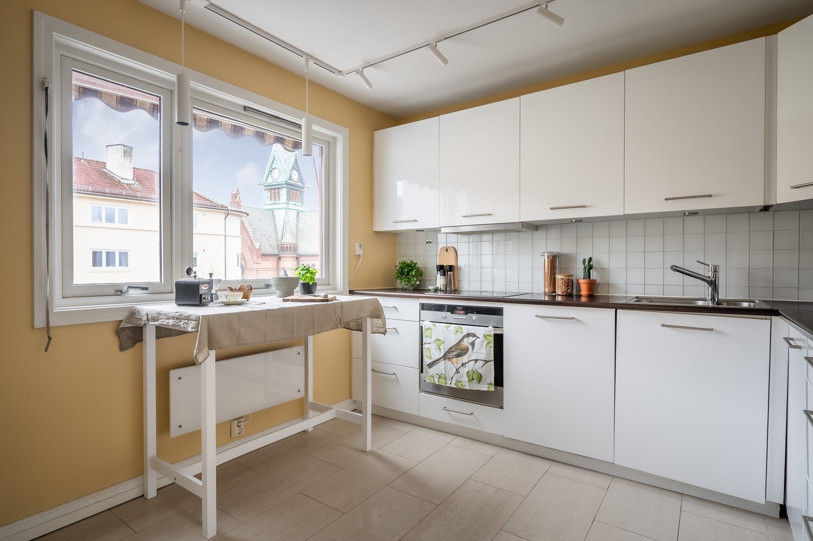 Innredningen består av hvite glatte fronter, benkeplater i laminat, fliser over benkeskap og rustfri oppvaskkum. Galleribilde