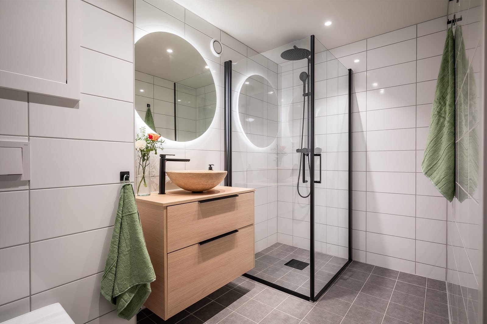 Pent bad fra 2024 med flislagte overflater, varmekabler og innfelte lys i himling. Galleribilde